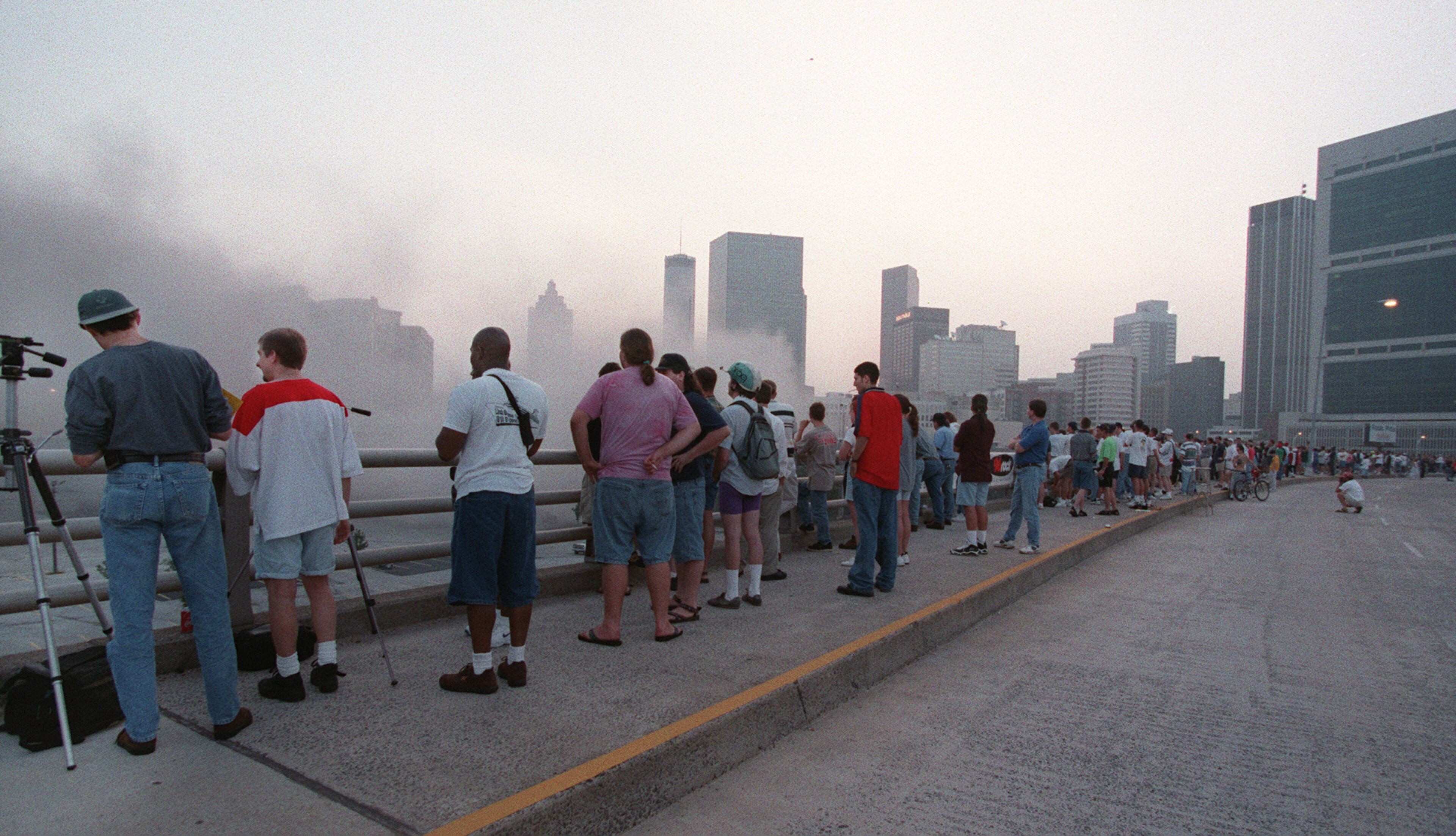 970726 - Atlanta, Georgia - Spectators watch from Martin Luther King Boulevard as a dark grey cloud of dust rolls across downtown Atlanta following the Omni arena implosion early Saturday morning, July 26, in downtown Atlanta. (AJC Staff Photo/Celine Bufkin)