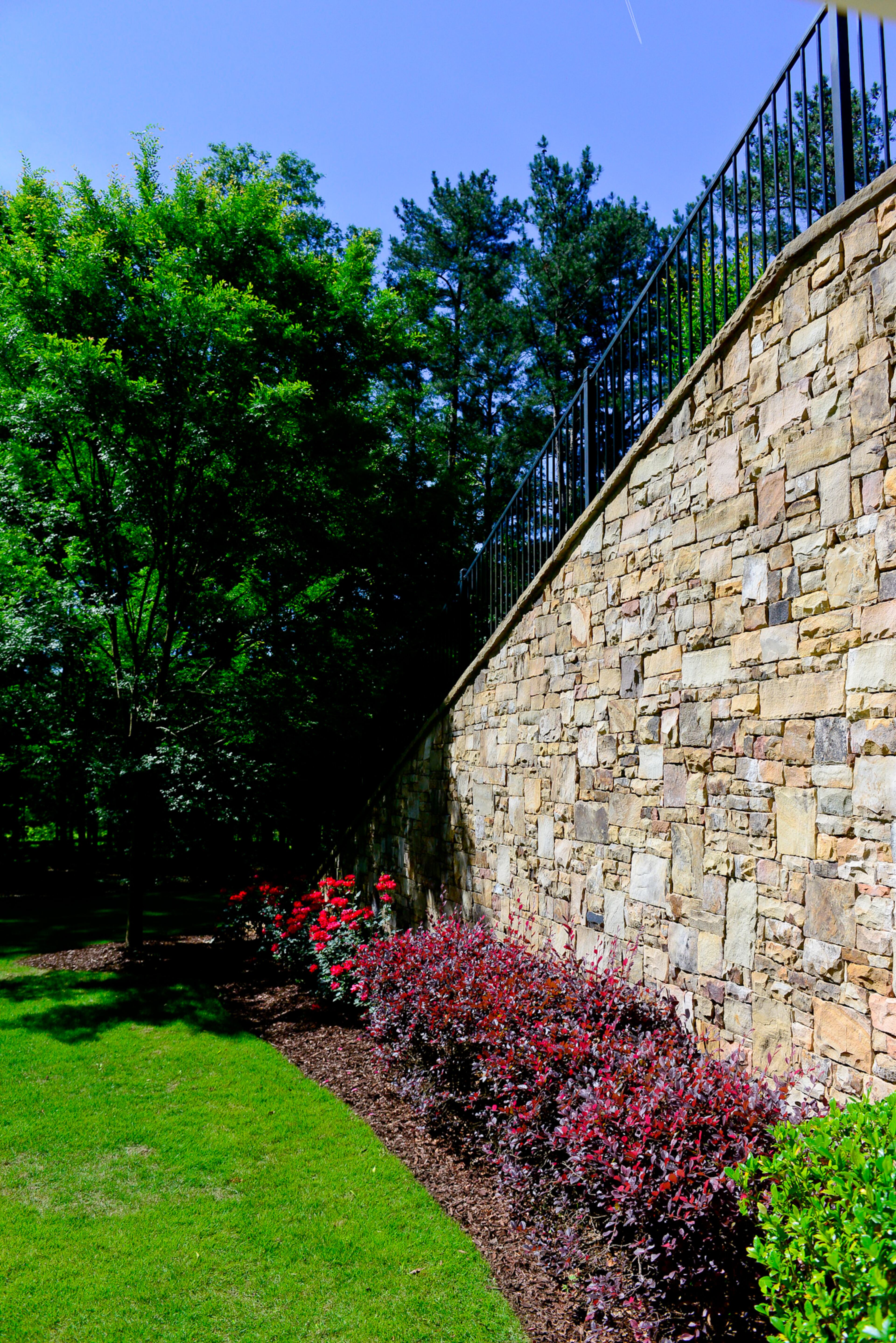 Stone surrounds the saltwater pool, which has brick paver decking. The homeowners wanted a walk-out pool and brought in loads of dirt to create access from the main level.
