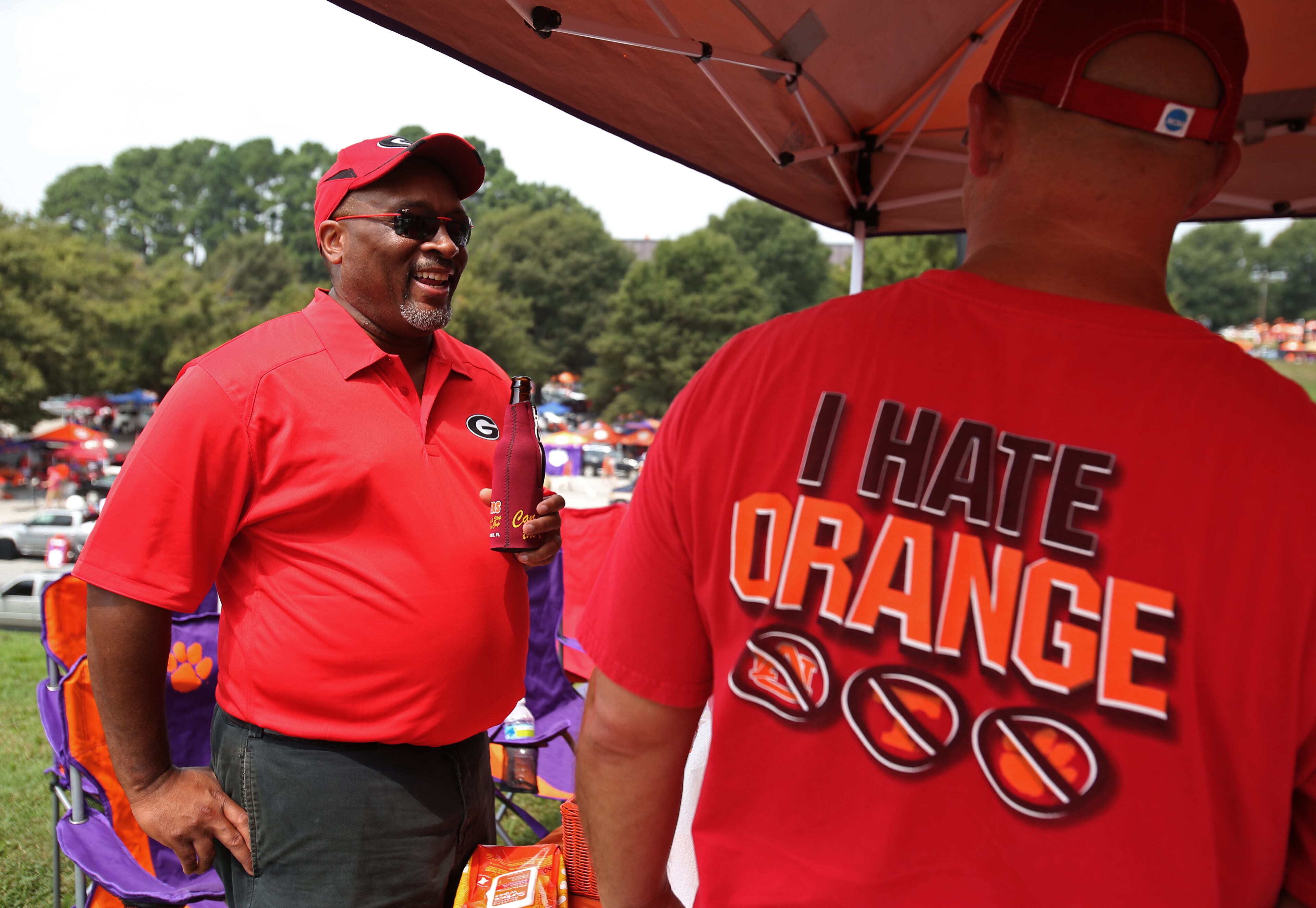 Georgia fan Ken Marshall, of Atlanta, left, talks with Moses Halcomb, of Lawrenceville, as they tailgate with Clemson fans before Saturday's game. JASON GETZ / JGETZ@AJC.COM