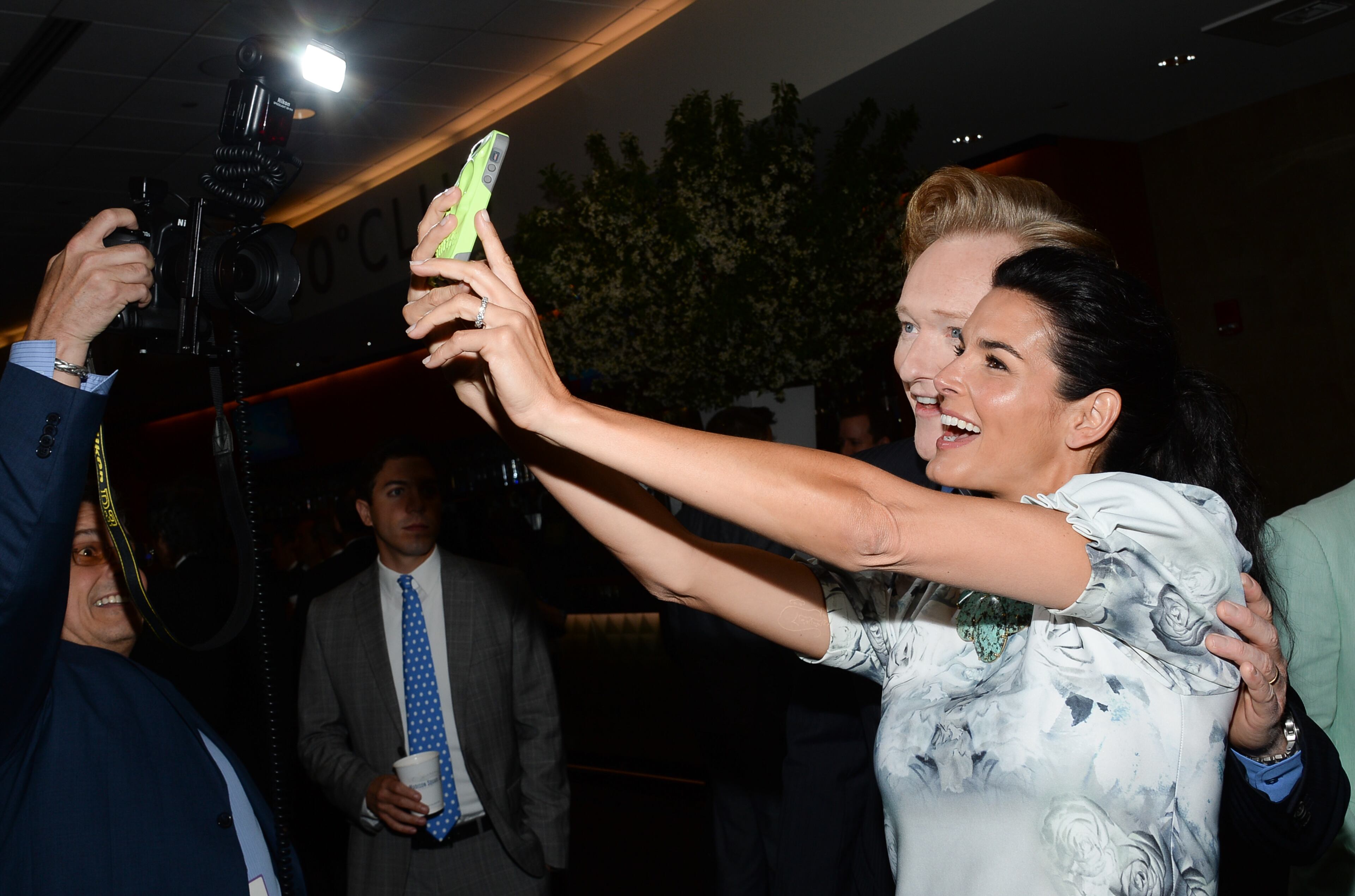 Conan O'Brien, and Angie Harmon, right, take a selfie backstage at the TNT and TBS Network 2014 Upfront Presentations at Madison Square Garden on Wednesday, May 14, 2014, in New York. (Photo by Evan Agostini/Invision/AP)