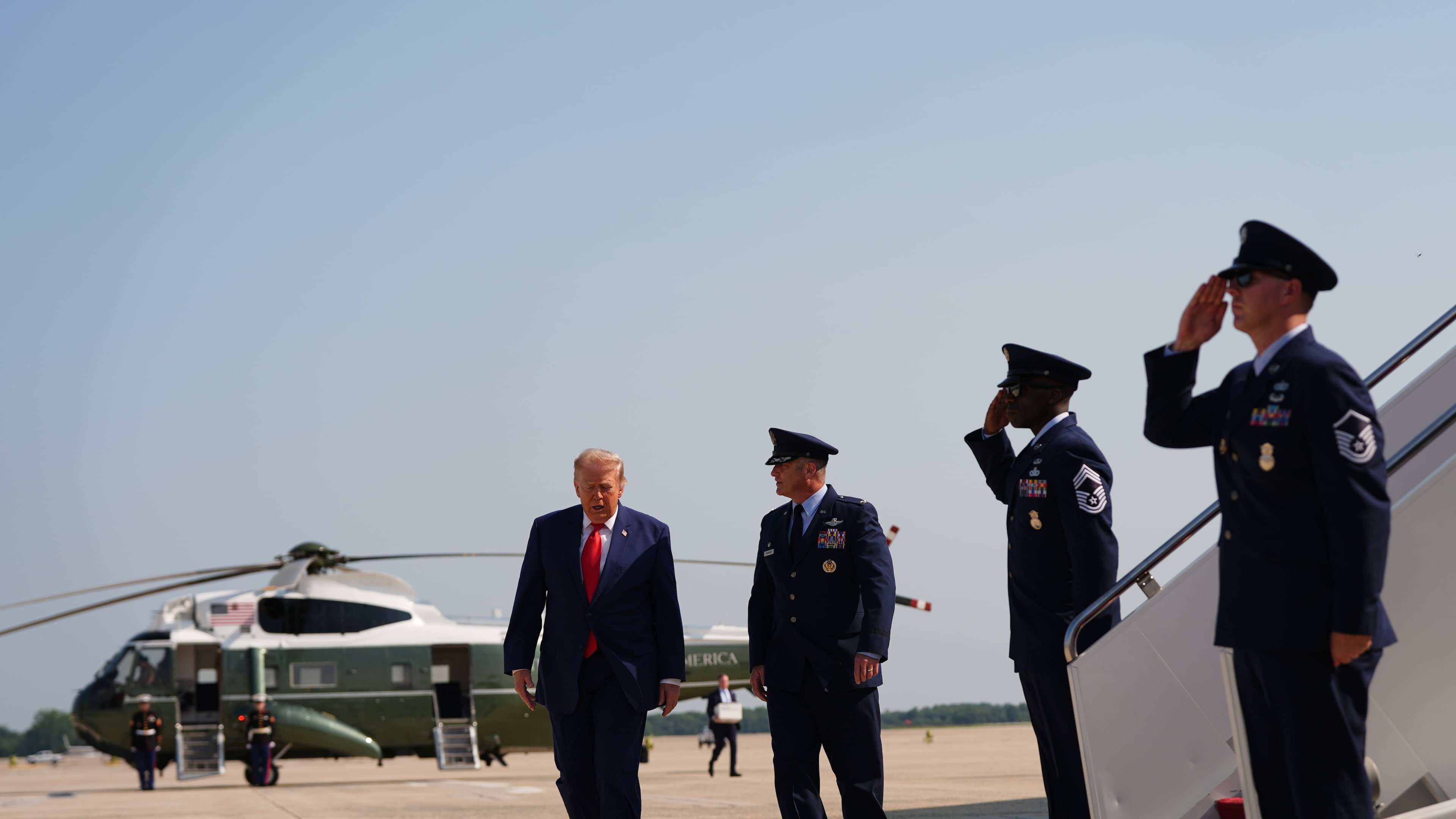 President Donald Trump, left, is escorted by Air Force Col. Christopher M. Robinson, Commander, 89th Airlift Wing, right, from Marine One to Air Force One, Wednesday, July 22, 2026, at Joint Base Andrews, Md. (AP Photo/Julia Demaree Nikhinson)