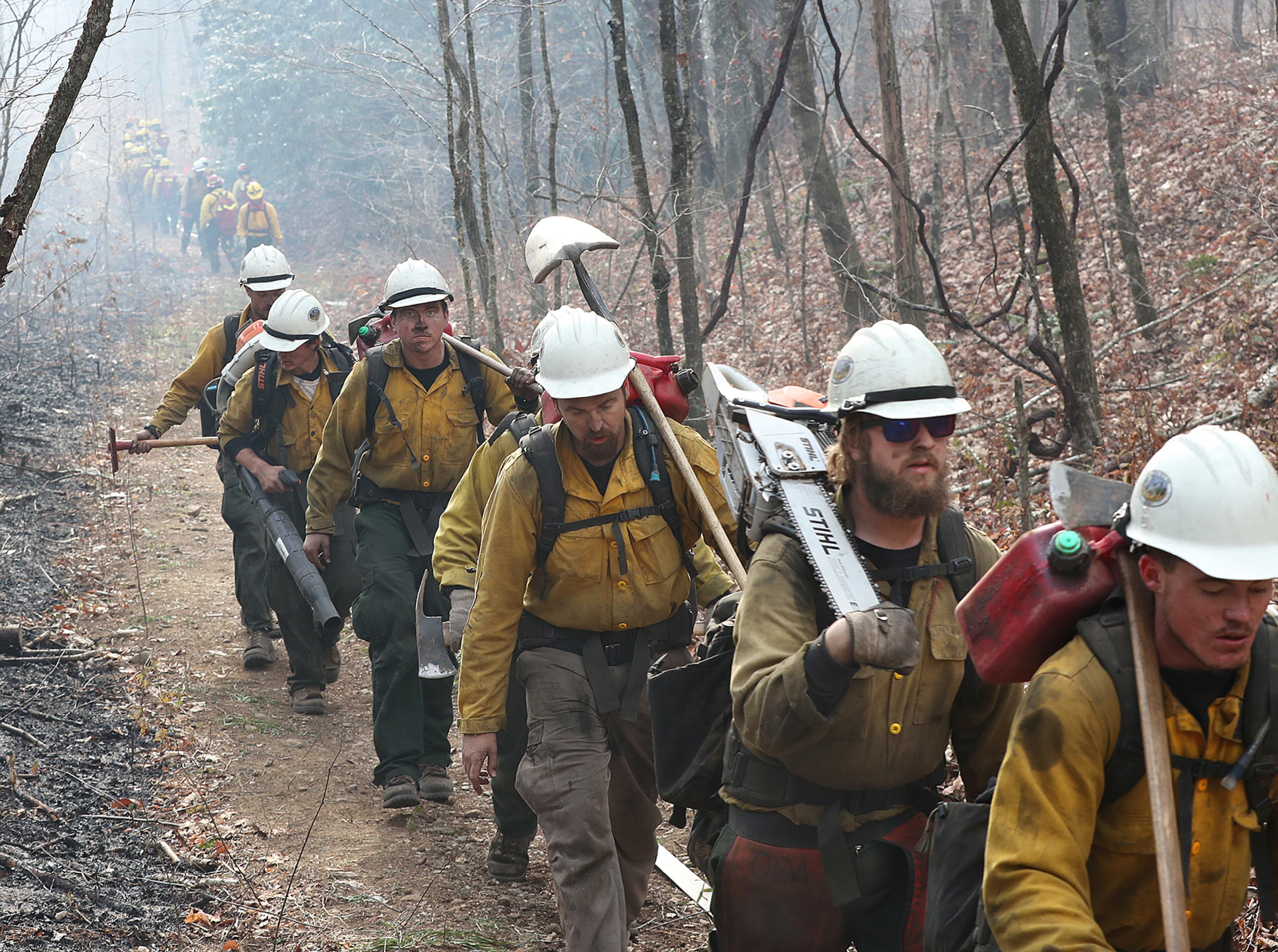 November 22, 2016, Tate City: ” BUMPING CREWS” A incoming California fire crew (right) walks in after working over night on the northern head of the Rock Mountain Fire along the Appalachian Trail at Deep Gap while a outgoing Oregon fire crew (far left) bumps them heading out for their long shift on Tuesday, Nov. 22, 2016, north of Tate City and the North Carolina border. The area is deep in the Natahala National Forest. Curtis Compton/ccompton@ajc.com