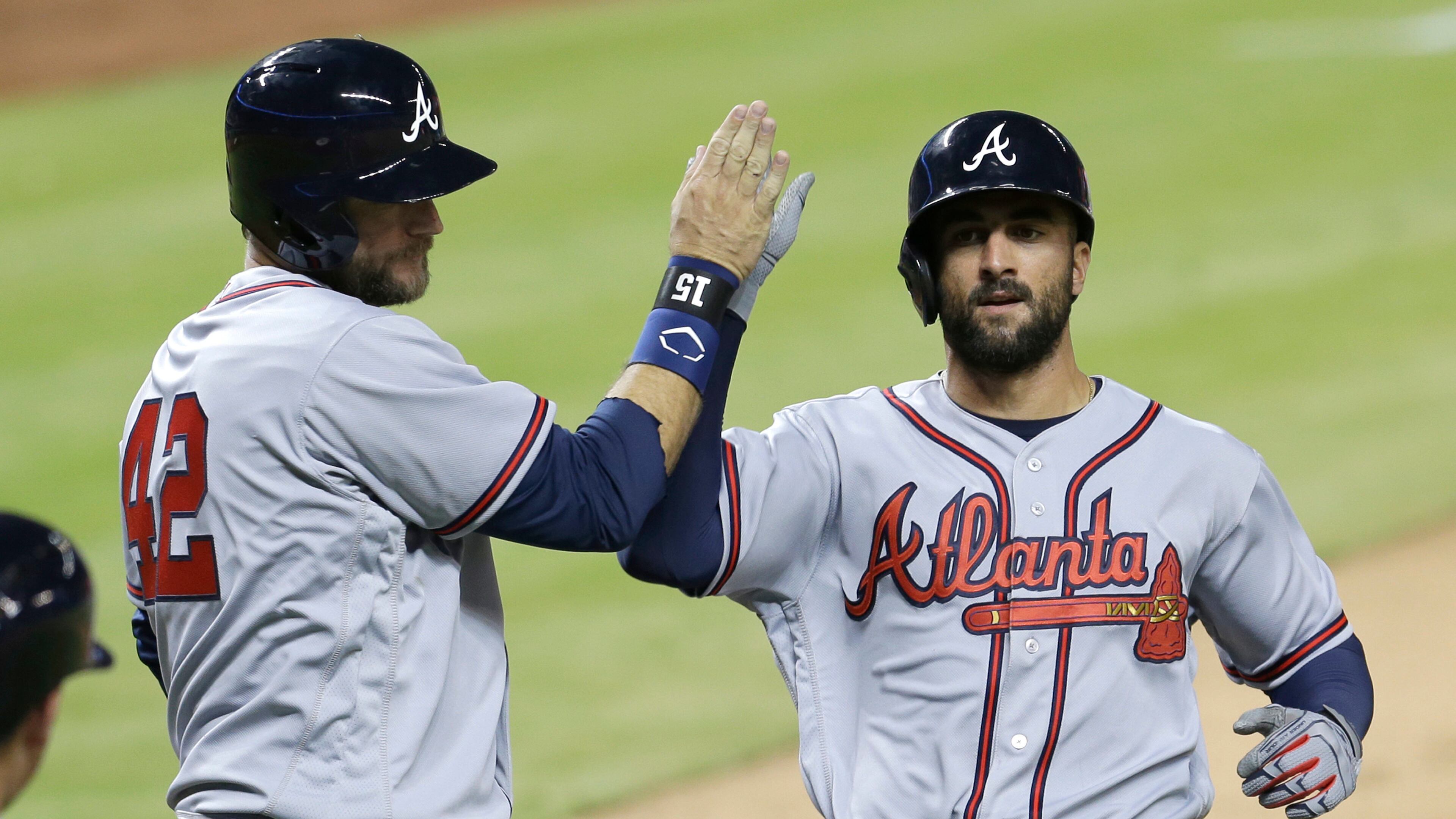 Atlanta Braves ' A.J. Pierzynski, left, high-fives Nick Markakis after both scored on base hit by Adonis Garcia during the eighth inning. (AP Photo/Alan Diaz)