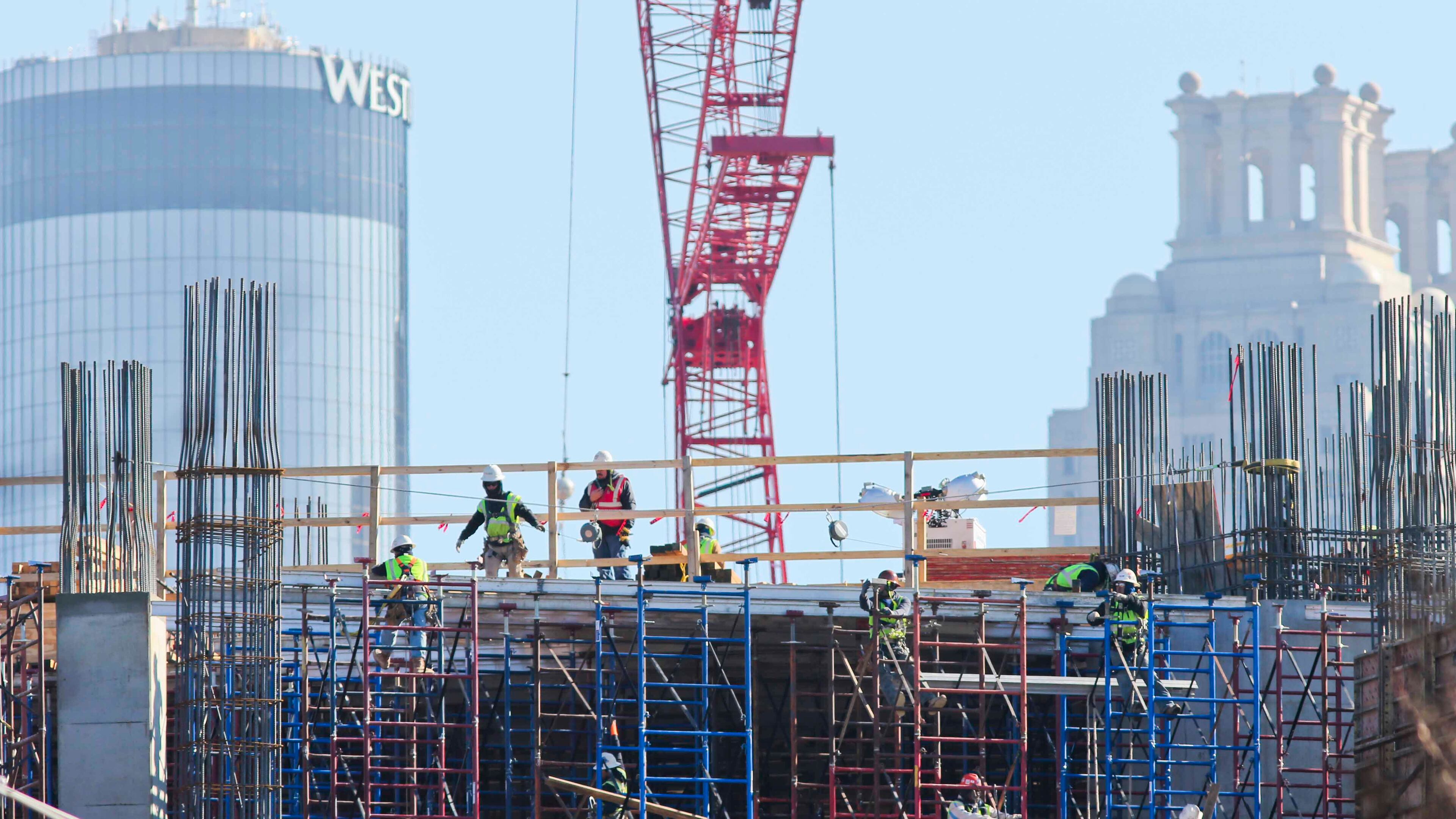 Workers clamber atop the bones of the new Falcons stadium downtown. Construction was among sectors showing healthy gains in the latest jobs report.