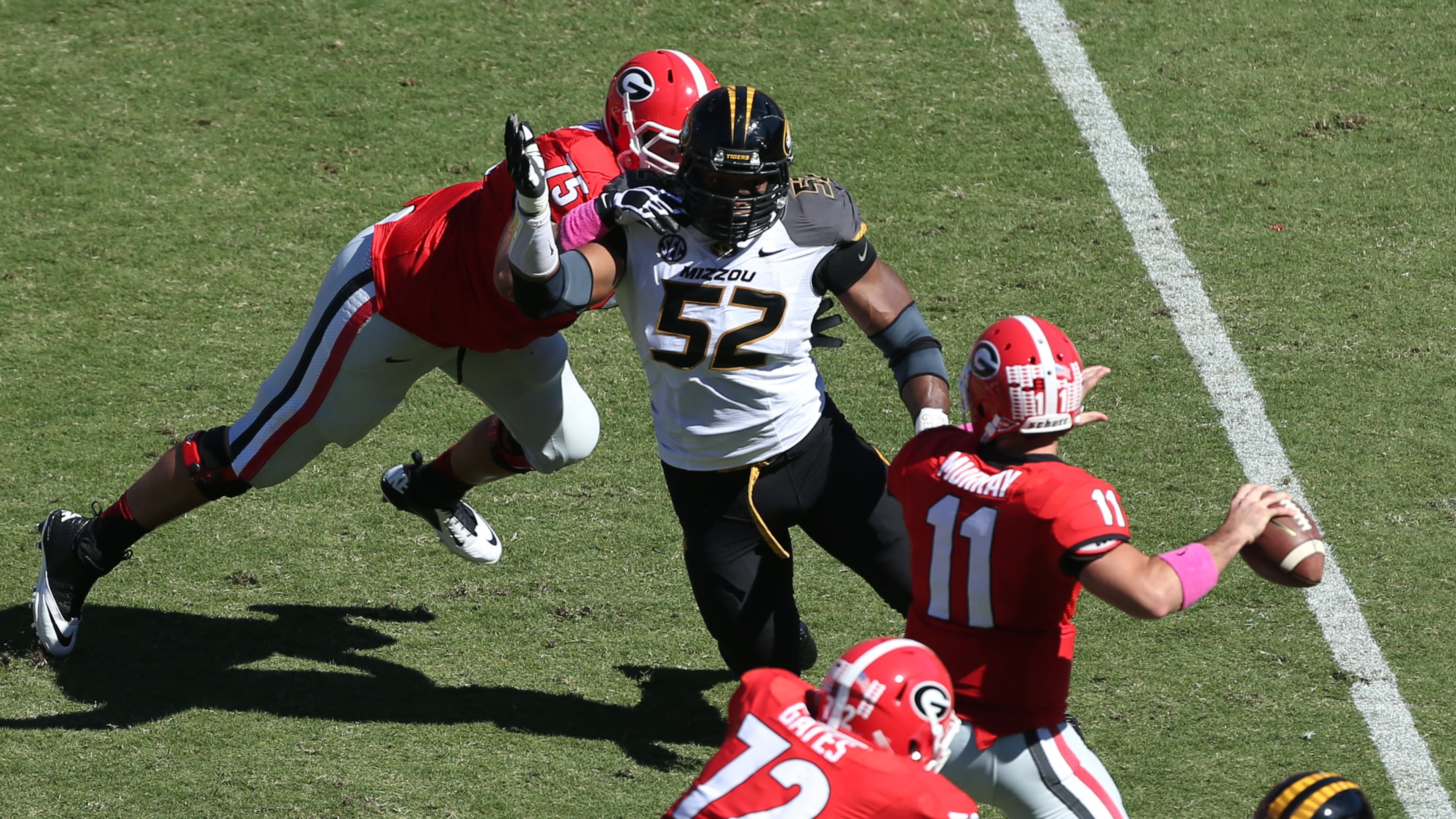 October 12, 2013 - Athens, Ga: Missouri Tigers defensive lineman Michael Sam (52) puts pressure on Georgia Bulldogs quarterback Aaron Murray (11) as Georgia Bulldogs offensive tackle Kolton Houston (75) attempts to block during their game at Sanford Stadium Saturday afternoon in Athens, Ga., October 12, 2013. Missouri defeated Georgia 41-26. Murray threw for 290 yards, 3 touchdowns, 2 interceptions and had a fumble returned for a touchdown in the loss. JASON GETZ / JGETZ@AJC.COM Missouri Tigers defensive lineman Michael Sam (52) puts pressure on Georgia Bulldogs quarterback Aaron Murray (11) as Georgia Bulldogs offensive tackle Kolton Houston (75) attempts to block during their game at Sanford Stadium Saturday afternoon in Athens, Ga., October 12, 2013. Missouri defeated Georgia 41-26. Murray threw for 290 yards, 3 touchdowns, 2 interceptions and had a fumble returned for a touchdown in the loss. JASON GETZ / JGETZ@AJC.COM