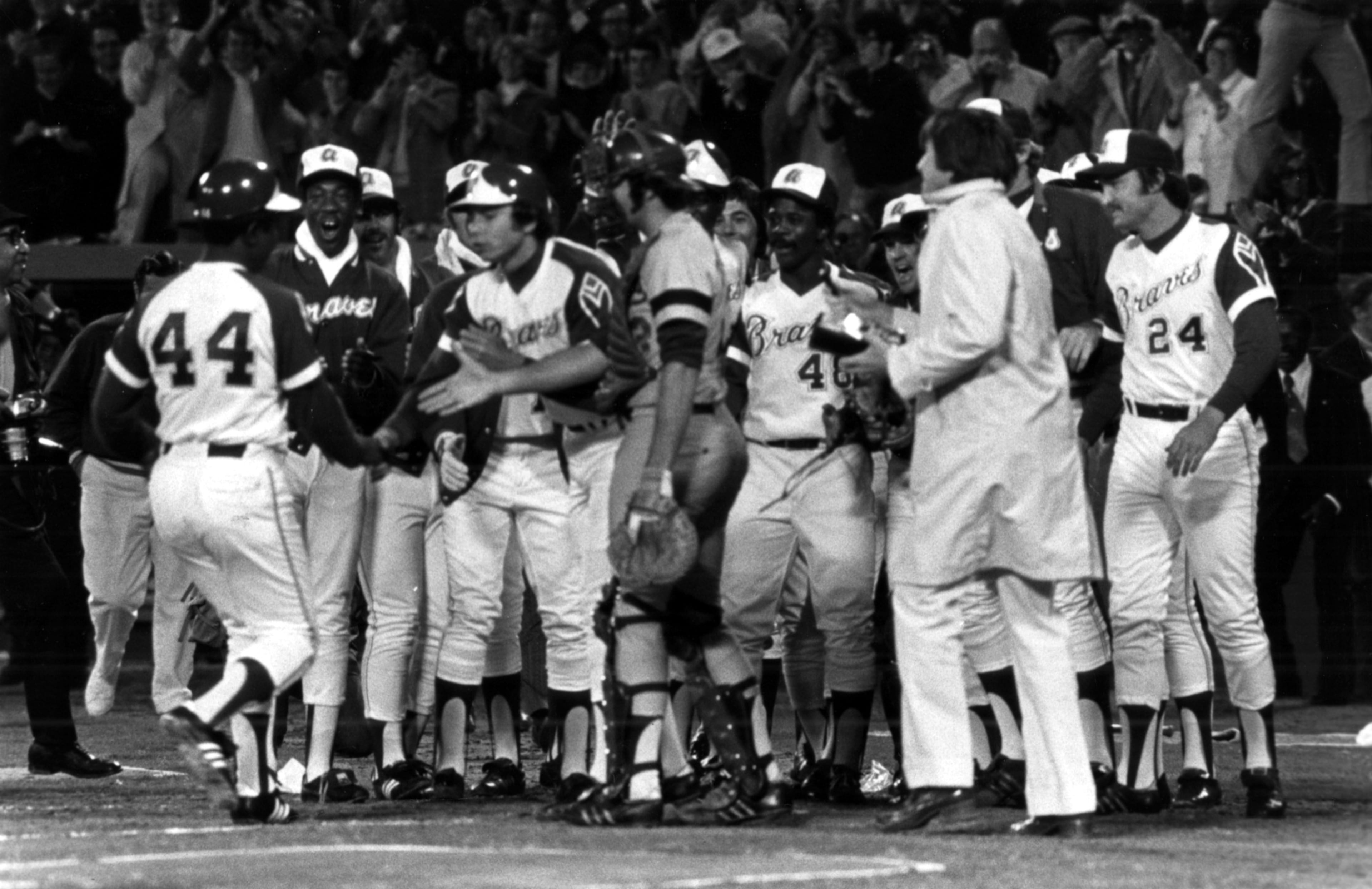 Braves players greet Aaron at home plate and Dodgers catcher Joe Ferguson even extends his hand.
