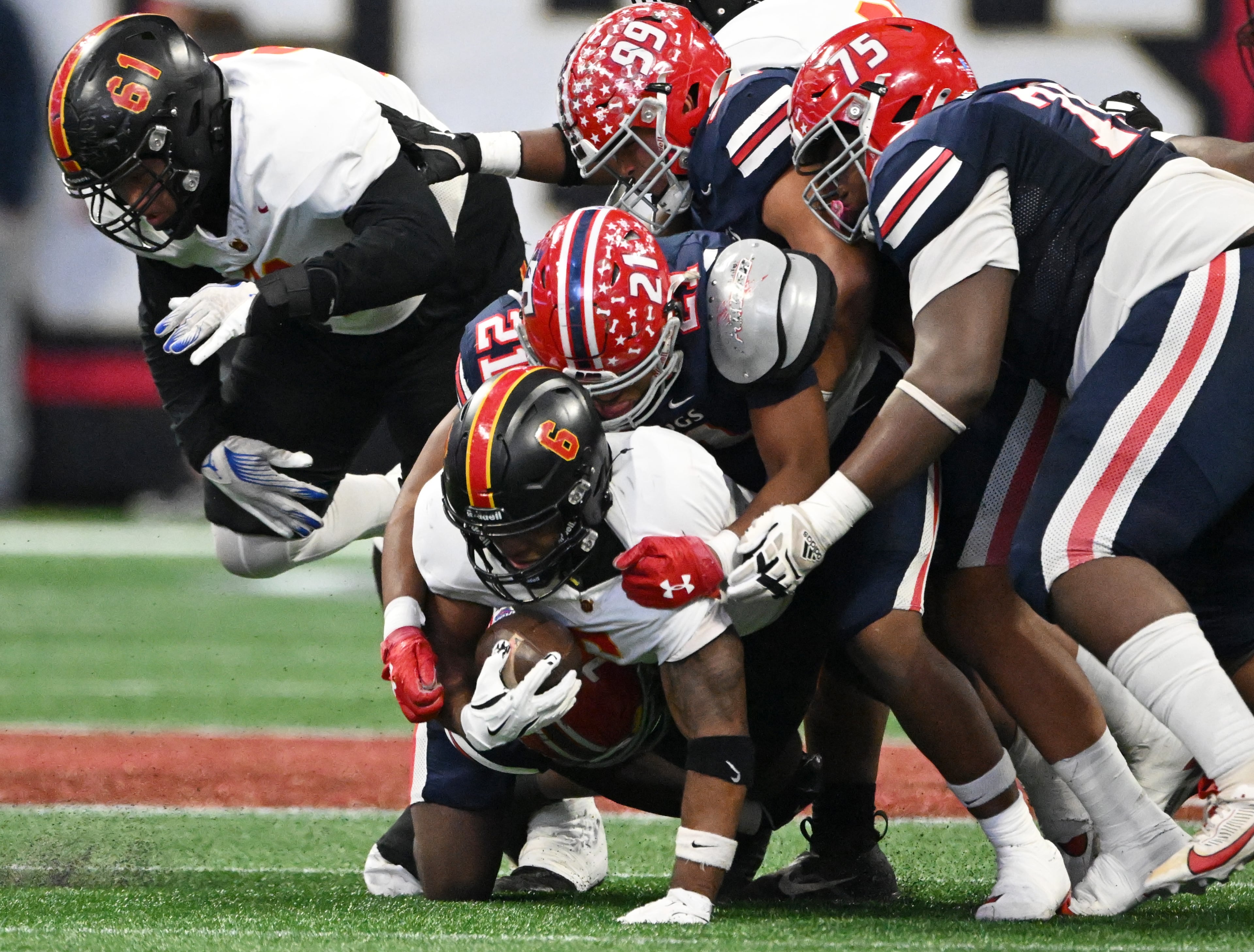 Northeast's running back Nick Woodford (6) is brought down by Toombs County's defensive lineman Zaylen Davis (21) and Toombs County's defensive lineman Hayden Bullard (99) during the first half in GHSA Class A-Division State Championship game at Mercedes-Benz Stadium, Tuesday, December 17, 2024, in Atlanta. (Hyosub Shin / AJC)