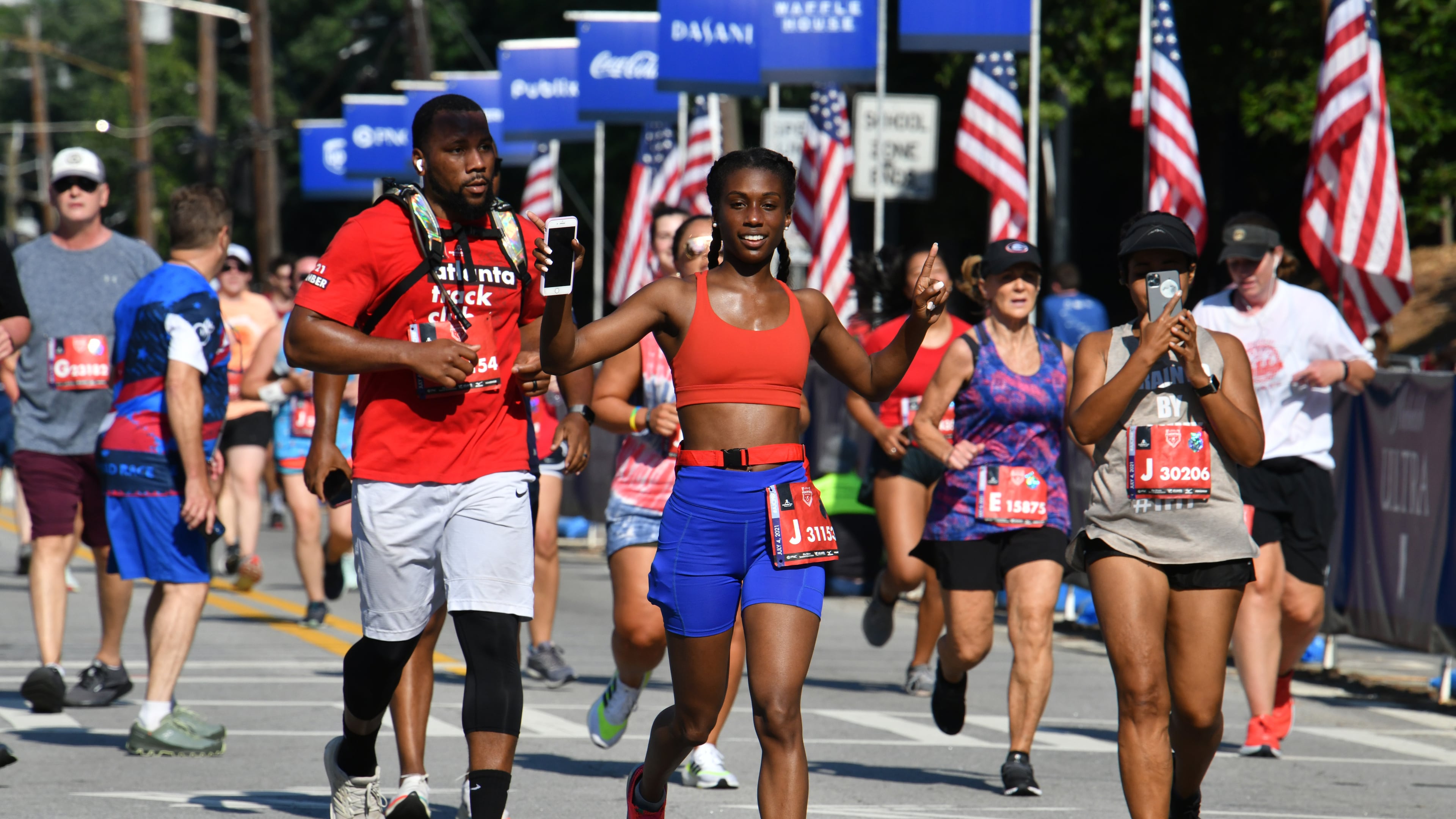 Runners make their way to cross the finish line during the second day of 2021 Atlanta Journal-Constitution Peachtree Road Race on Sunday, July 4, 2021. (Hyosub Shin / Hyosub.Shin@ajc.com)