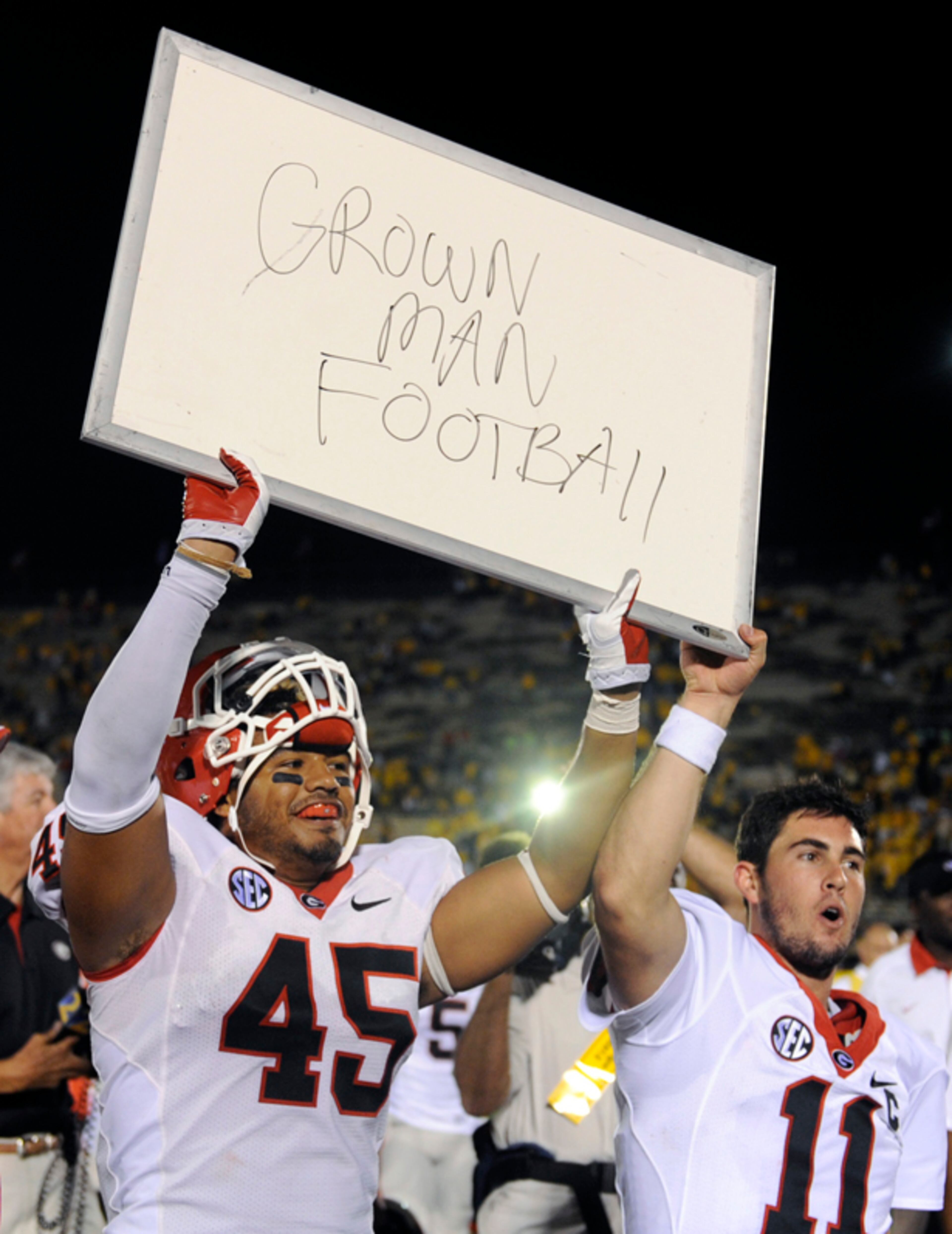 Georgia's Christian Robinson (left) and teammate Aaron Murray hold up a sign - making reference to earlier comments from a Missouri player - that reads "Grown Man Football," following Georgia's 41-20 victory over Missouri.