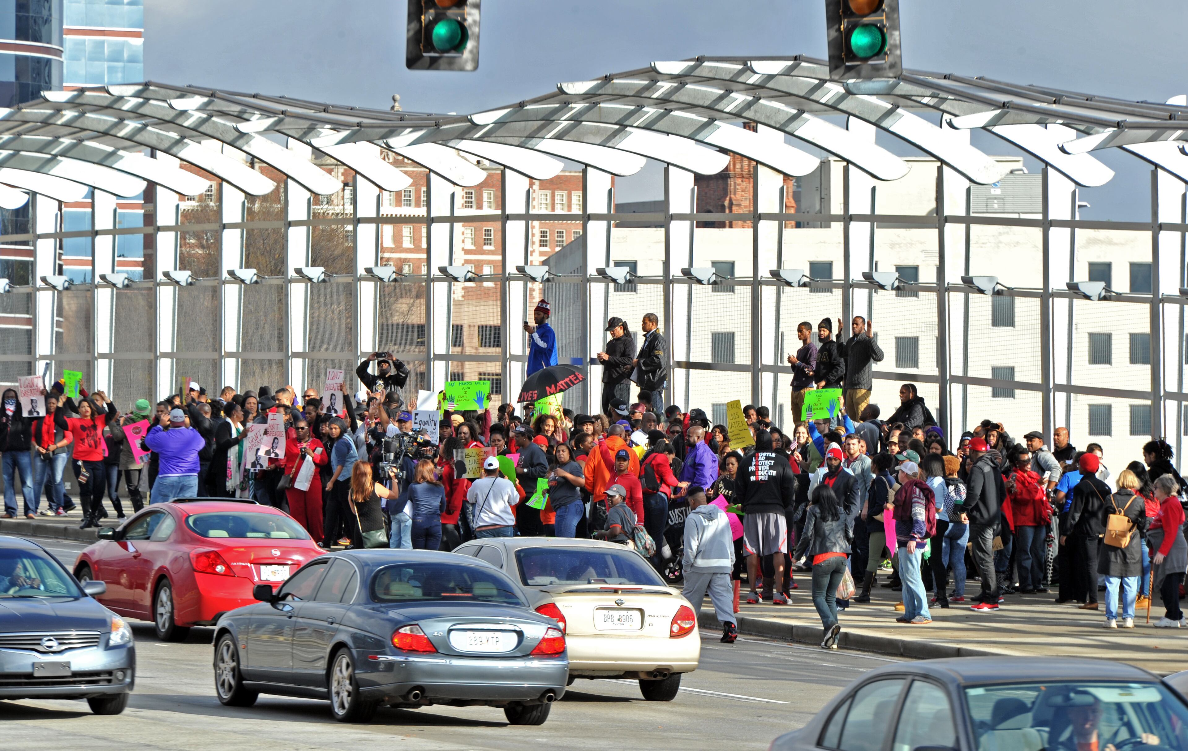 December 6, 2014 Atlanta - Protesters gather to participate in a "die-in" on the 17th Street Bridge near Atlantic Station during their peaceful demonstration against decisions not to indict white police officers in the deaths of unarmed black men in Ferguson, Mo., and in New York City on Saturday, December 6, 2014. HYOSUB SHIN / HSHIN@AJC.COM