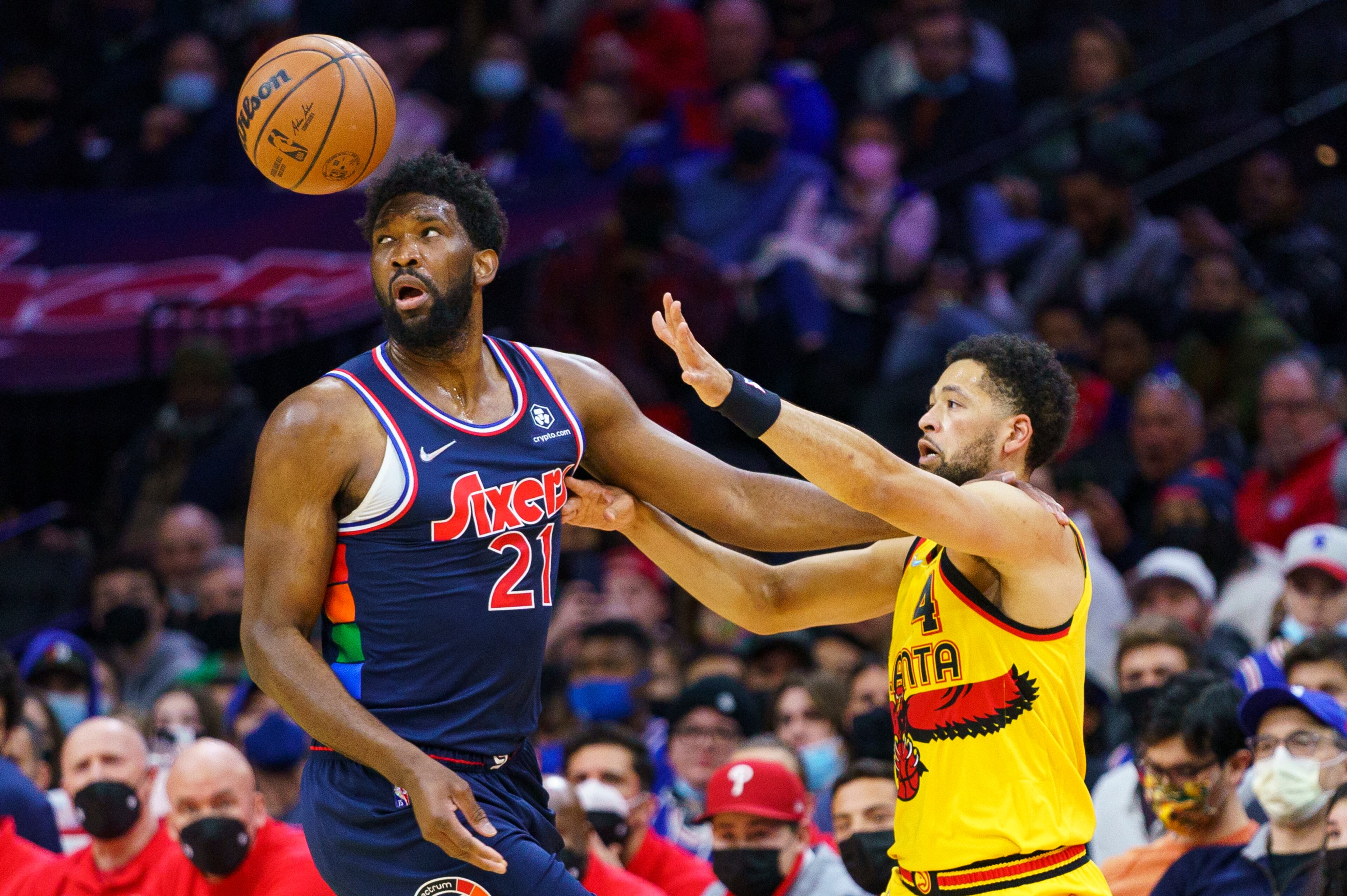 Joel Embiid watches the ball that had been knocked away as he fends off Skylar Mays of the Hawks during the first half of Thursday's game in Philadelphia. (AP Photo/Chris Szagola)