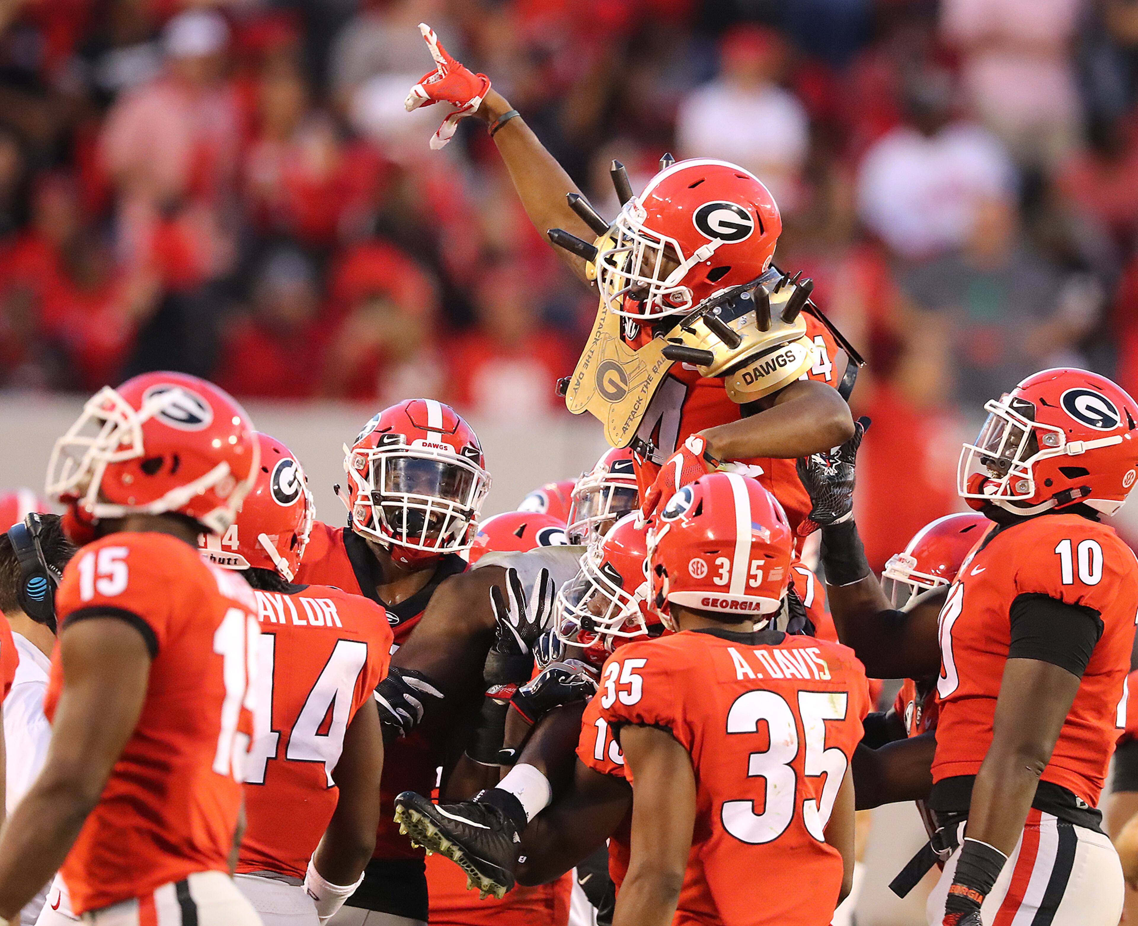 *** POSSIBLE VISUAL LEDE *** November 4, 2017 Athens: Georgia players carry cornerback Malkom Parrish off the field on their shoulders wearing the Dawg spikes after he intercepted South Carolina quarterback Jake Bentley in the final minutes of the game for a 24-10 victory and a 9-0 record in a NCAA college football game on Saturday, November 4, 2017, in Athens. Curtis Compton/ccompton@ajc.com