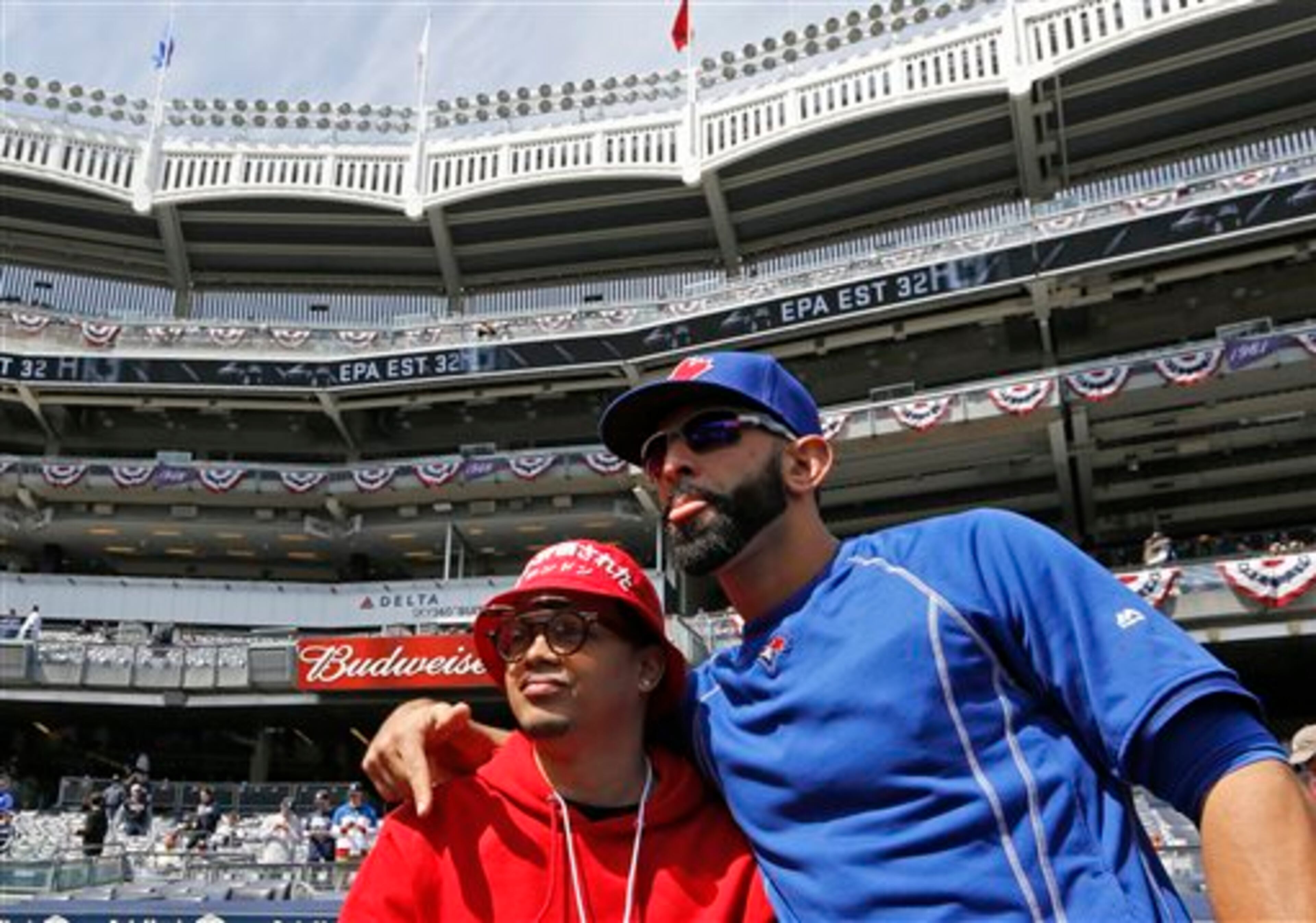 Toronto Blue Jays' Jose Bautista, right, poses for a photo with a fan during pregame warmups before an opening day baseball game against the New York Yankees in New York, Monday, April 6, 2015. (AP Photo/Kathy Willens)