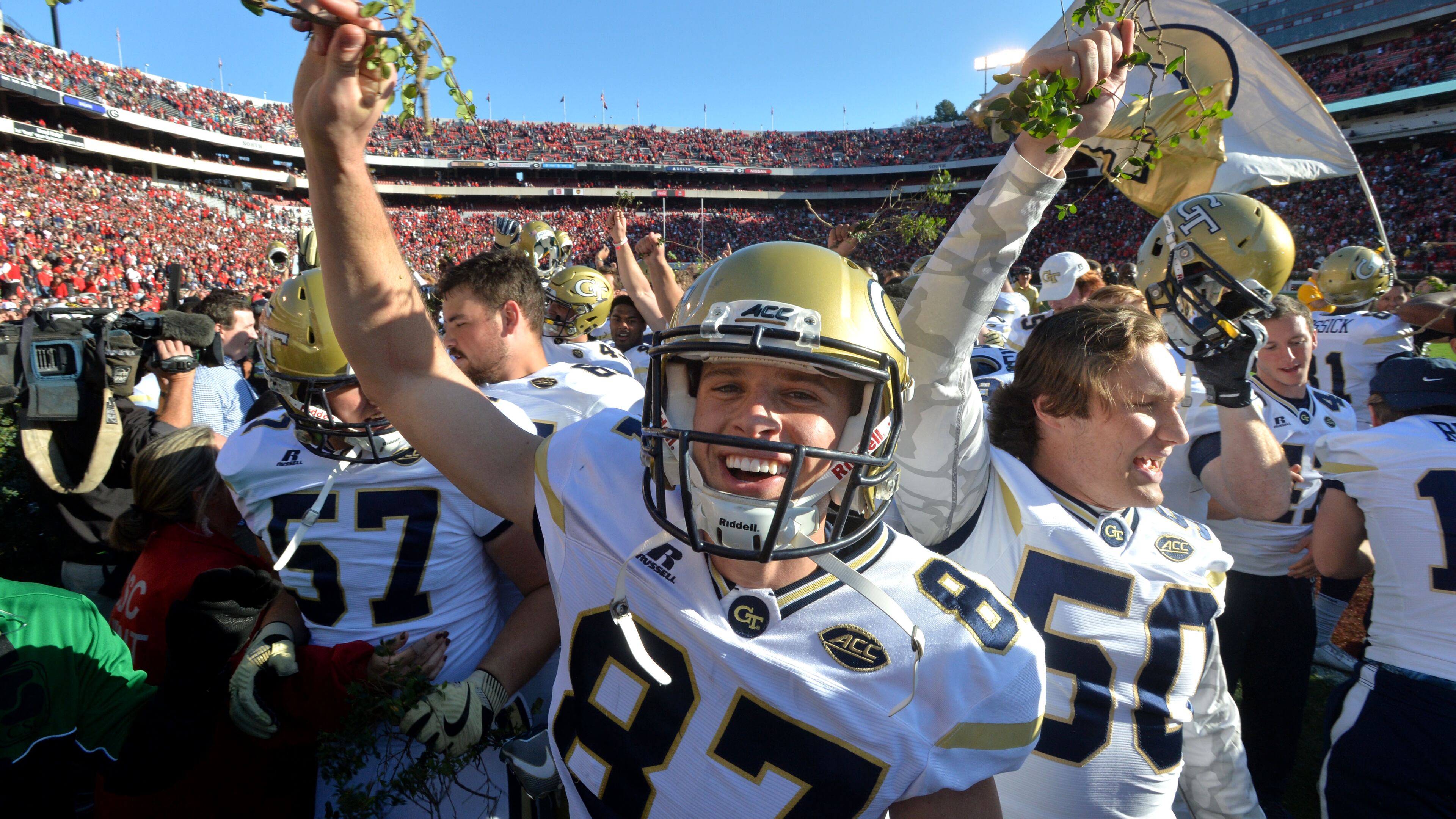Georgia Tech place kicker Harrison Butker (87) and other players celebrate their 28-27 win over Georgia with a piece of the Sanford Stadium hedges at Sanford Stadium on Saturday, November 26, 2016. HYOSUB SHIN / HSHIN@AJC.COM
