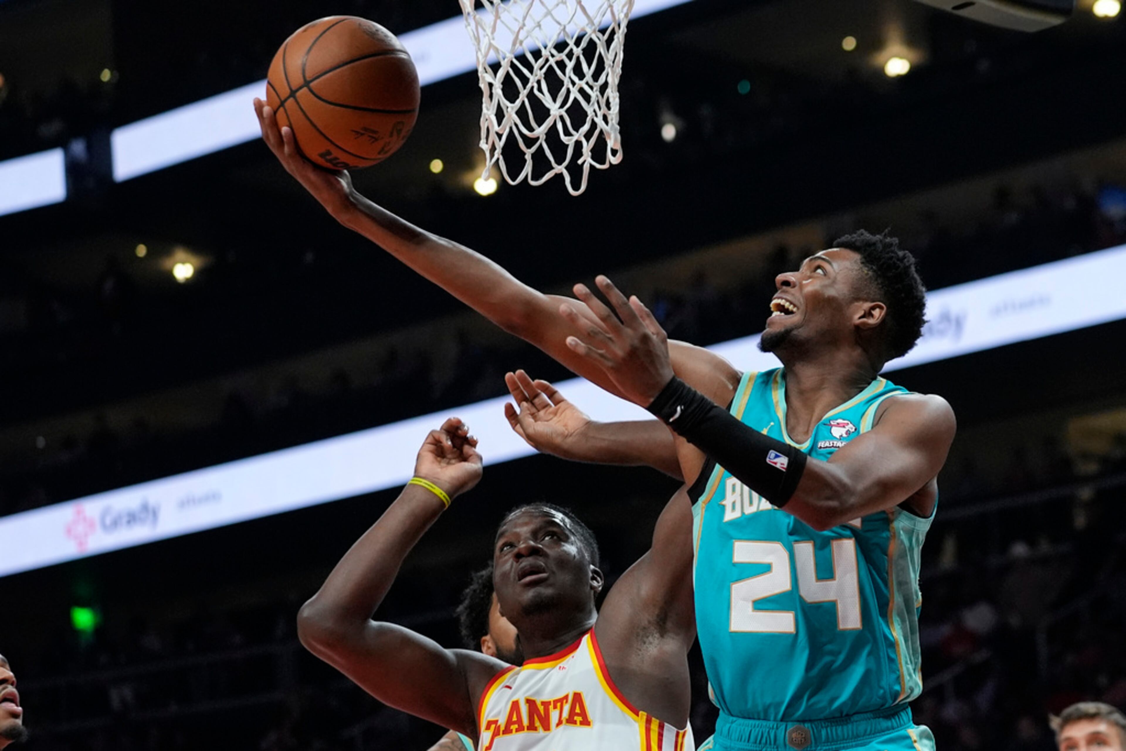 Charlotte Hornets forward Brandon Miller (24) scores as Atlanta Hawks center Clint Capela (15) defends during the first half of an NBA basketball Saturday, March 23, 2024, in Atlanta. (AP Photo/John Bazemore)