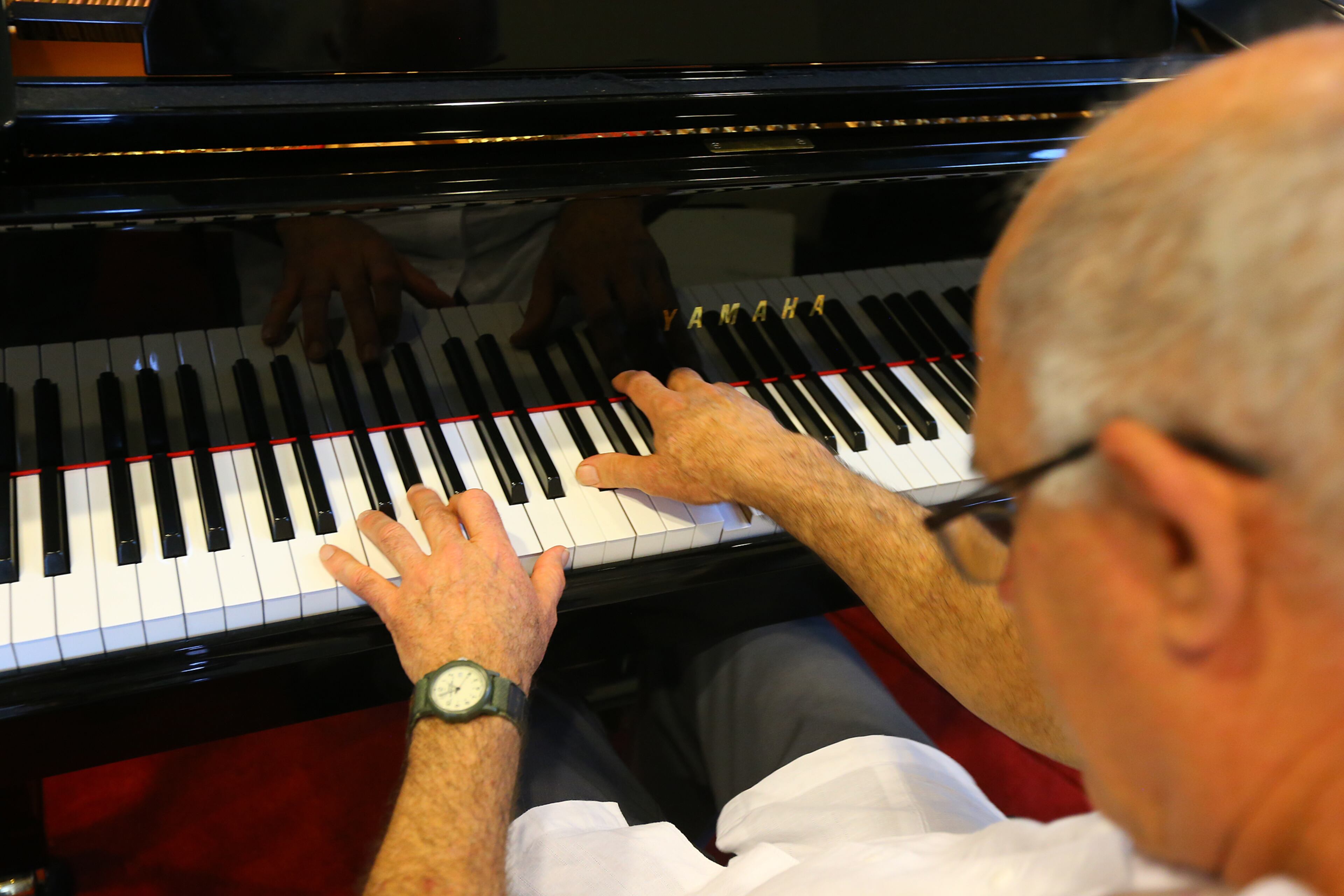 Atlanta singer/songwriter Bruce Gilbert, who struggles to continue to perform as his Parkinson's worsens, plays in the lobby of the Winship Cancer Institute in Atlanta on Tuesday, Oct. 14, 2014. Winship helped save Gilbert's wife from cancer, so he plays the piano in the lobby as a thank you to the center. CURTIS COMPTON / CCOMPTON@AJC.COM