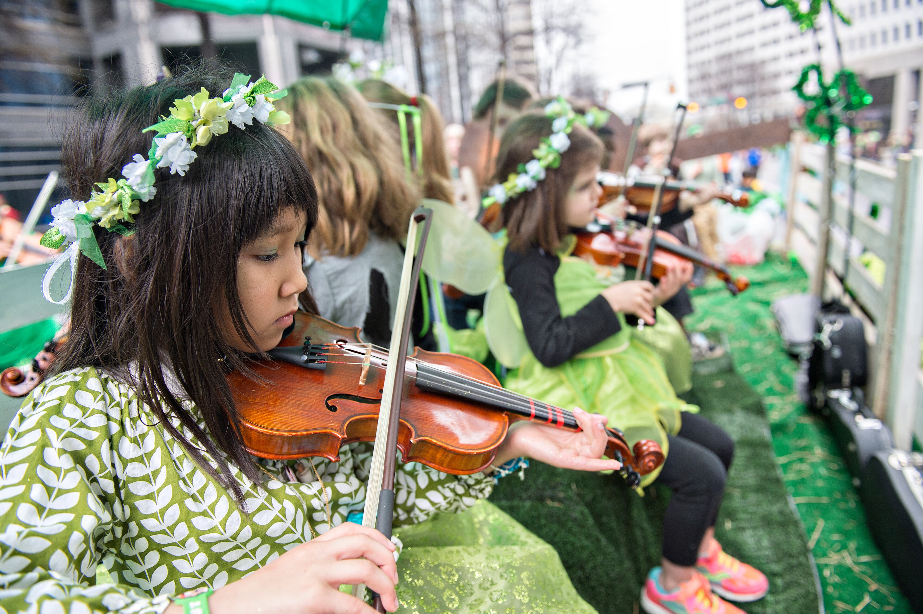 Isabel Salehbhai (left) plays the fiddle as she rides down Peachtree Street during the 2015 Atlanta St. Patrick's Parade on Saturday, March 14, 2015. Thousands of people attend the parade which dates back to 1858. JONATHAN PHILLIPS / SPECIAL