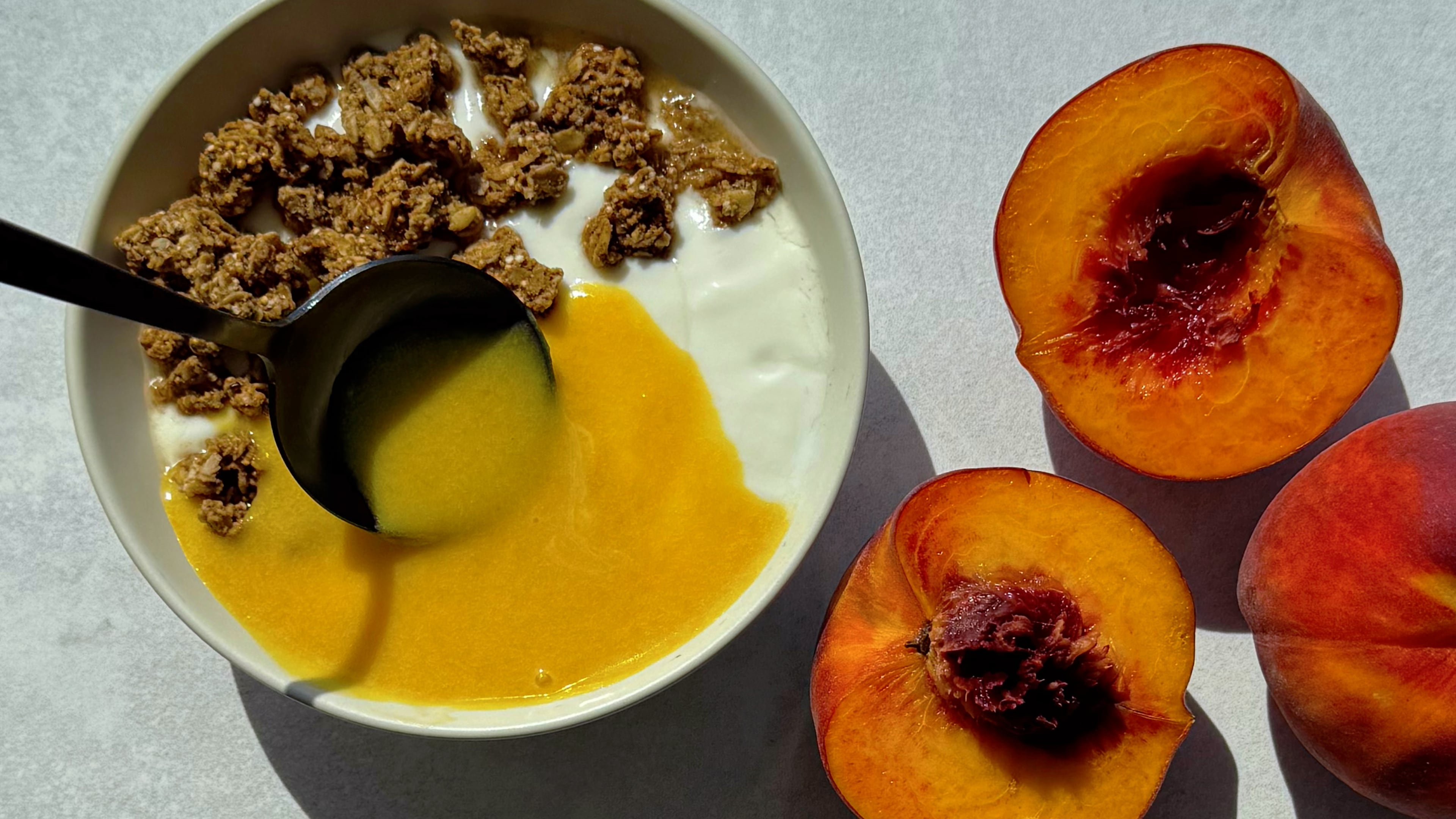 Breakfast, but make it dessert: Spoon sweet peach curd over a creamy yogurt granola bowl. (Monti Carlo/AJC)