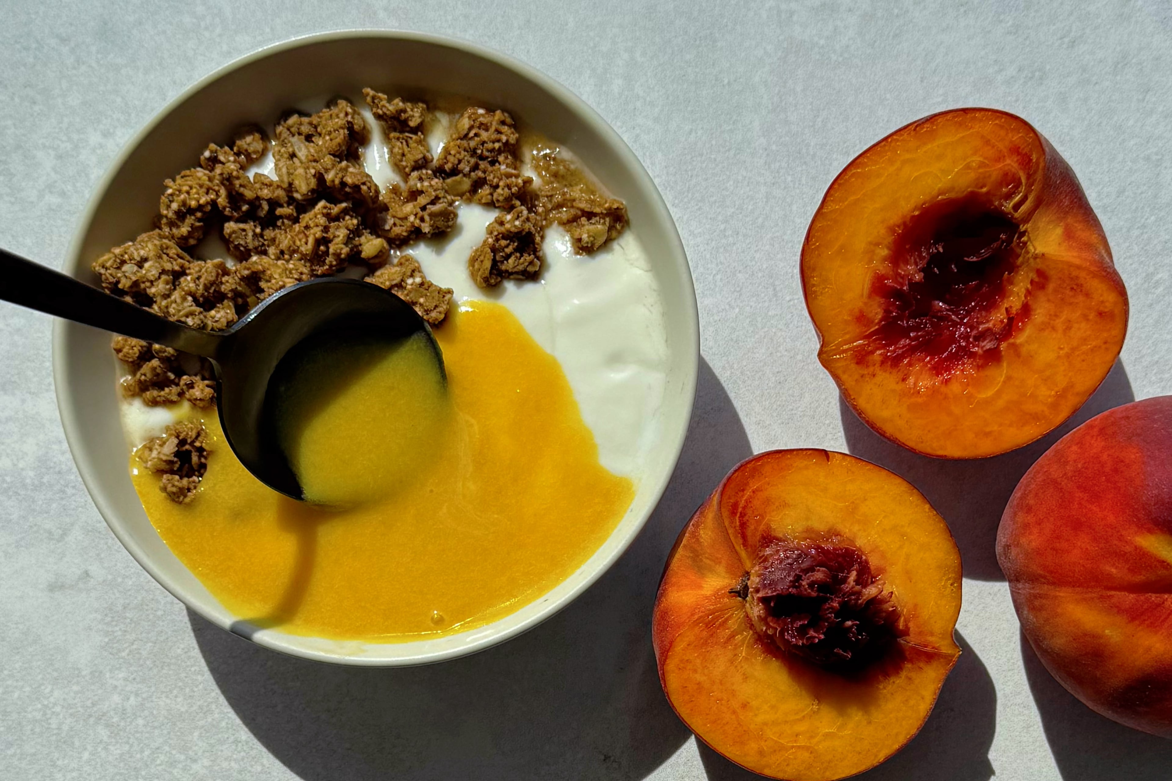 Breakfast, but make it dessert. Sweet peach curd over a creamy yogurt granola bowl. (Monti Carlo/AJC)