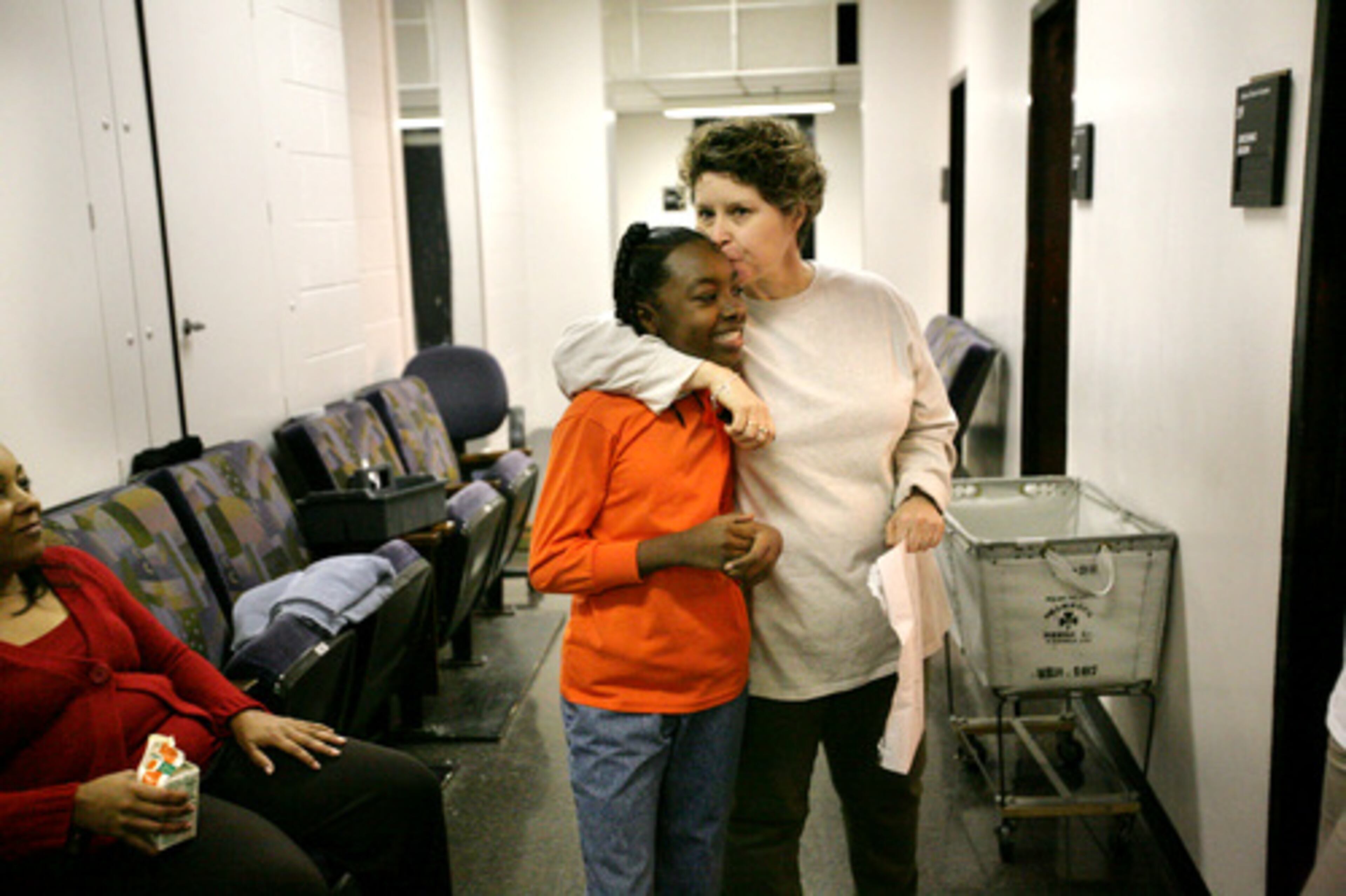 Stage manager Colleen Janich gives Jamiah a kiss on the forehead as Jamiah's grandmother Patrisha Cummings watches.