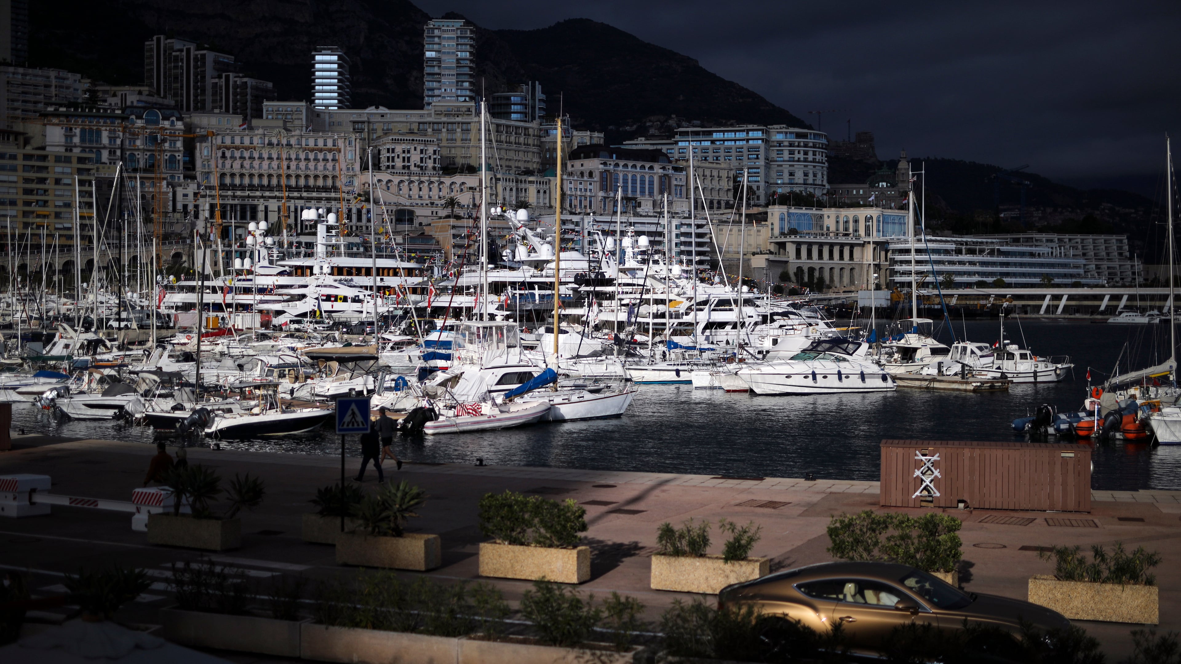 FILE - A luxury car drives along Monaco Harbor, Nov. 19, 2020. (AP Photo/Daniel Cole, File)
