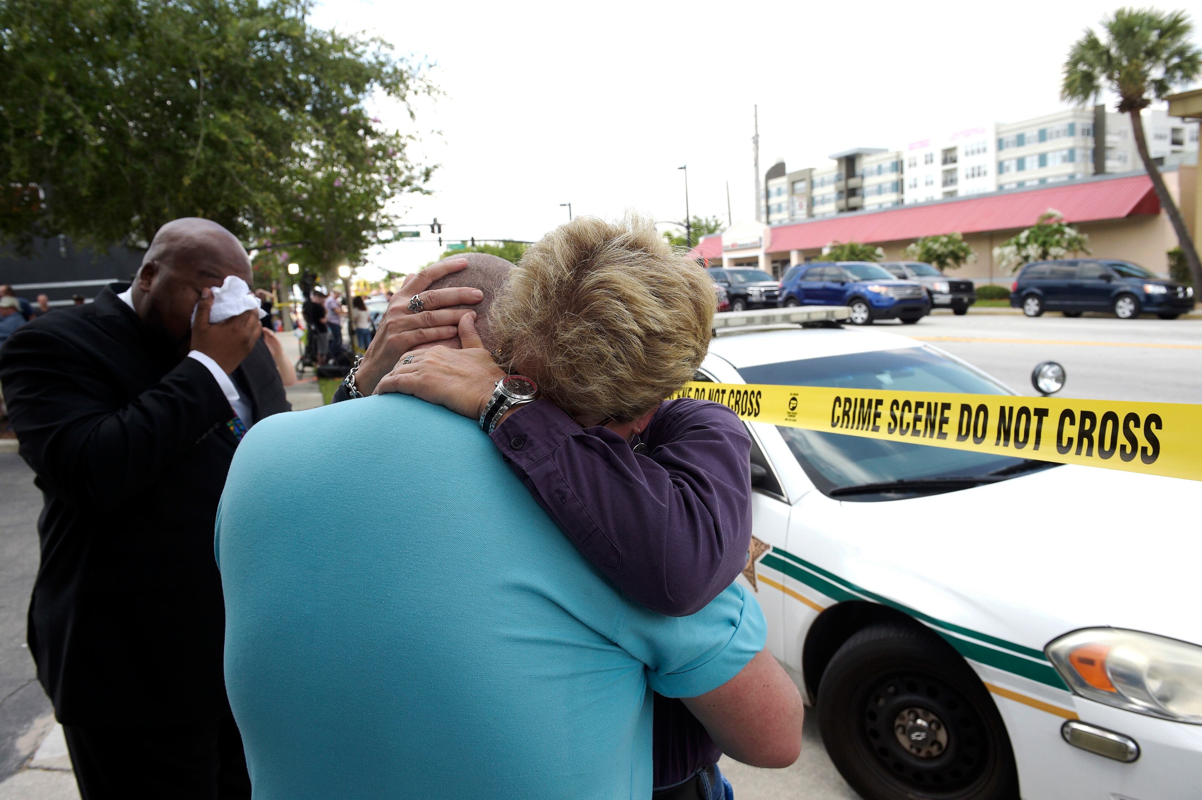 Terry DeCarlo, executive director of the LGBT Center of Central Florida, center, is comforted by Orlando City Commissioner Patty Sheehan, right, after a shooting involving multiple fatalities at a nightclub in Orlando, Fla., Sunday, June 12, 2016. (AP Photo/Phelan M. Ebenhack)