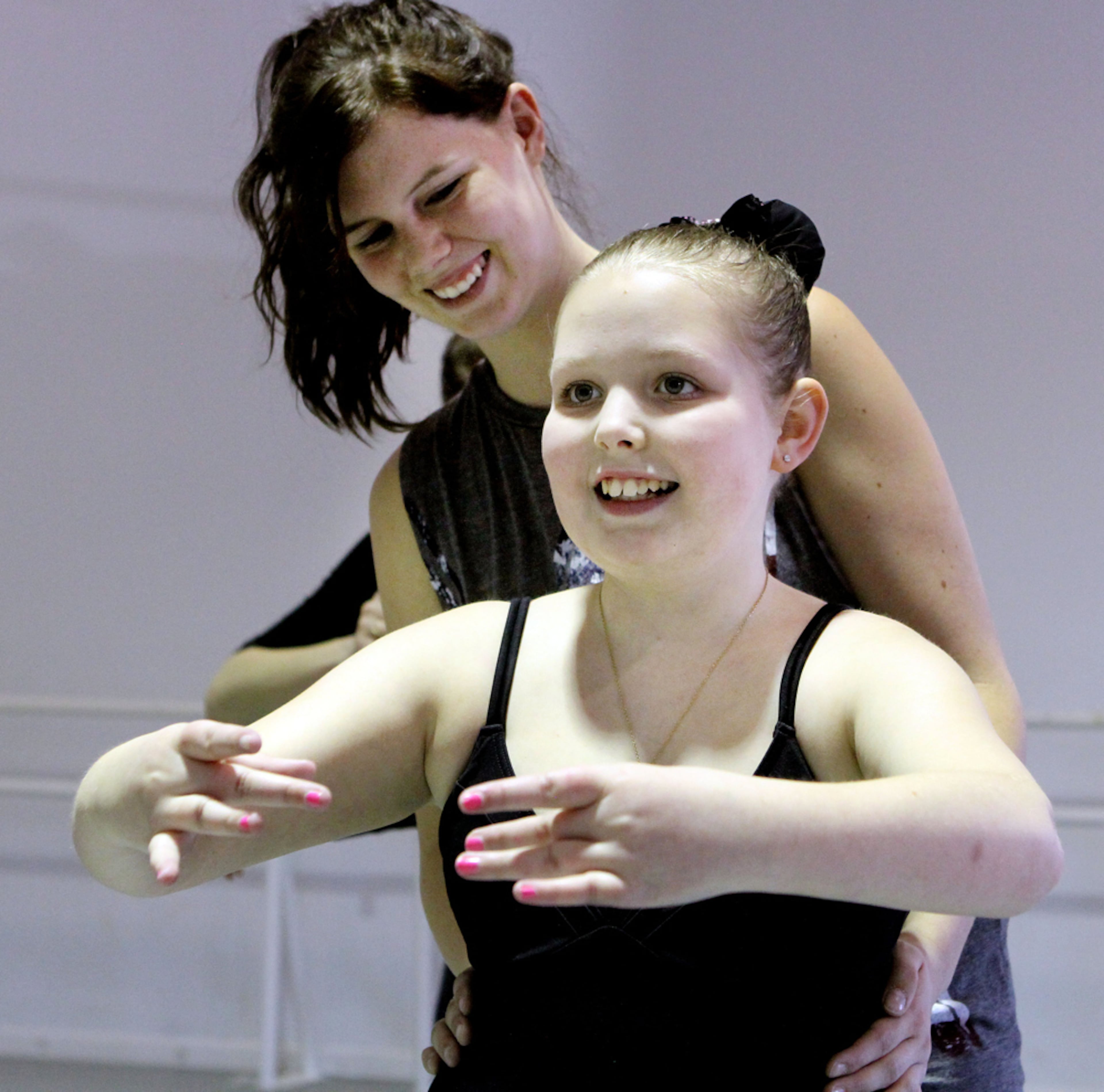 MARCH 14, 2013-ATLANTA: Bria Cantrell (left) helps eleven-year-old Courtney Hicks as she participates in a free ballet program created by the Georgia Ballet in Marietta for children with special needs on Thursday March 14th, 2013. The DanceAbility Program is in its second year has helped Hicks get back into dancing. She is a brain cancer survivor who was diagnosed just before her dance recital. The removal of the tumor left her body unable to walk, talk, or even feed herself at first. Her courage and undaunted spirit have enabled her to re-learn all those basic skills and even to return the art form that she loved before she became ill. When her insurance coverage ran out and could no longer provide physical therapy for her last year, her parents were looking for something to help her continue to make progress in overcoming her physical limitations. DanceAbility has helped Courtney make incredible progress. Last year she used to wheel her wheelchair to the studio and then practice. Jumping was practically impossible and balancing was very difficult. After her summer off, she returned jumping up and down (literally), ready to come to ballet again. She continues to learn to jump, gallop, and can even balance on her toes for short periods of time now. PHIL SKINNER / PSKINNER@AJC.COM editor's note: CQ