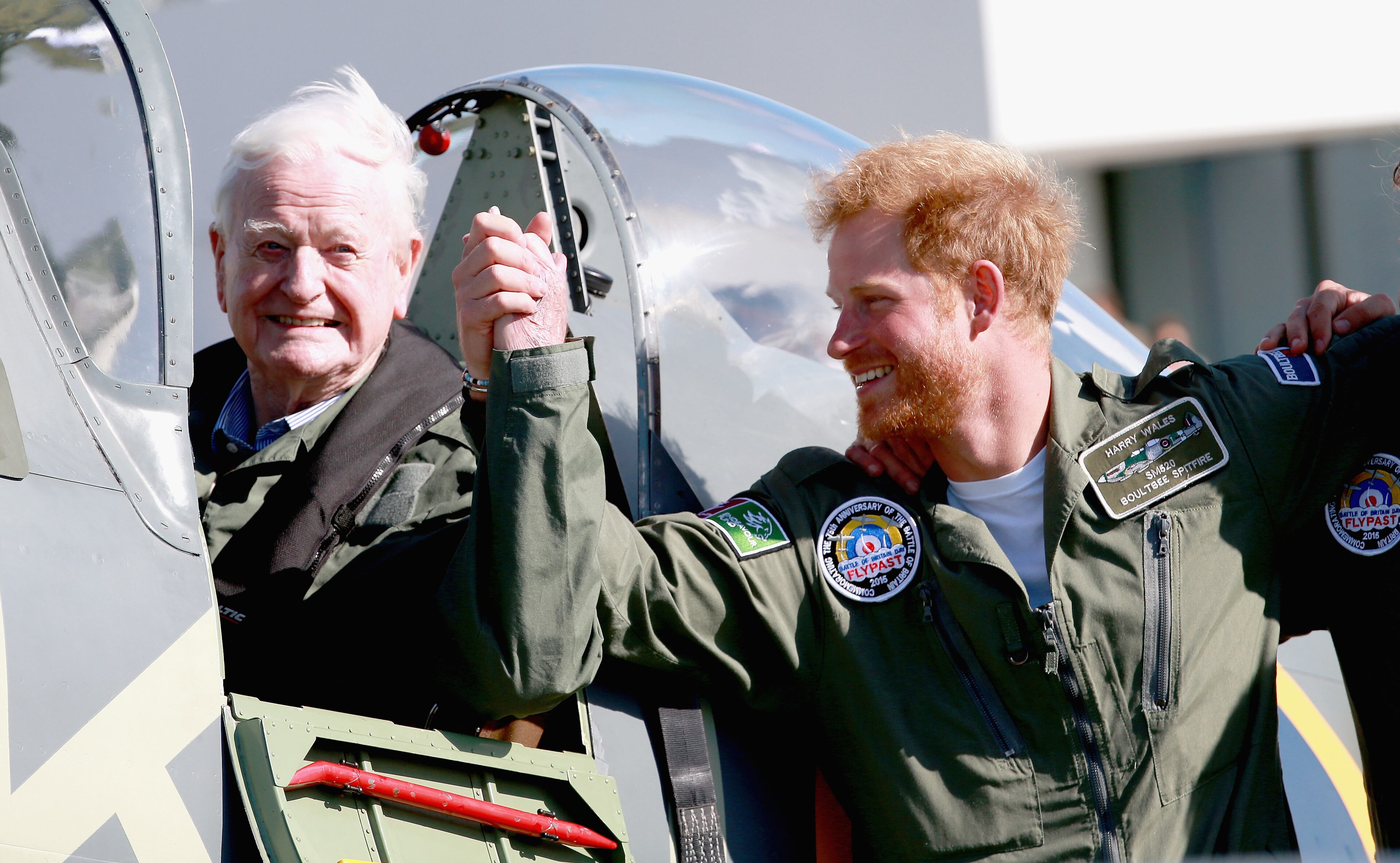CHICHESTER, ENGLAND - SEPTEMBER 15: Prince Harry holds hands with 95 year old Battle of Britain Veteran Tom Neil after he landed back at Goodwood Aerodrome in his Spitfire after a Battle of Britain Flypast at Goodwood on September 15, 2015 in Chichester, England. The 75th Anniversary of the Battle of Britain is being marked by a historic flypast that brings more Battle of Britain aircraft together than ever before as a show of thanks to 'the few' and the sacrifices they made. (Photo by Chris Jackson/Getty Images)