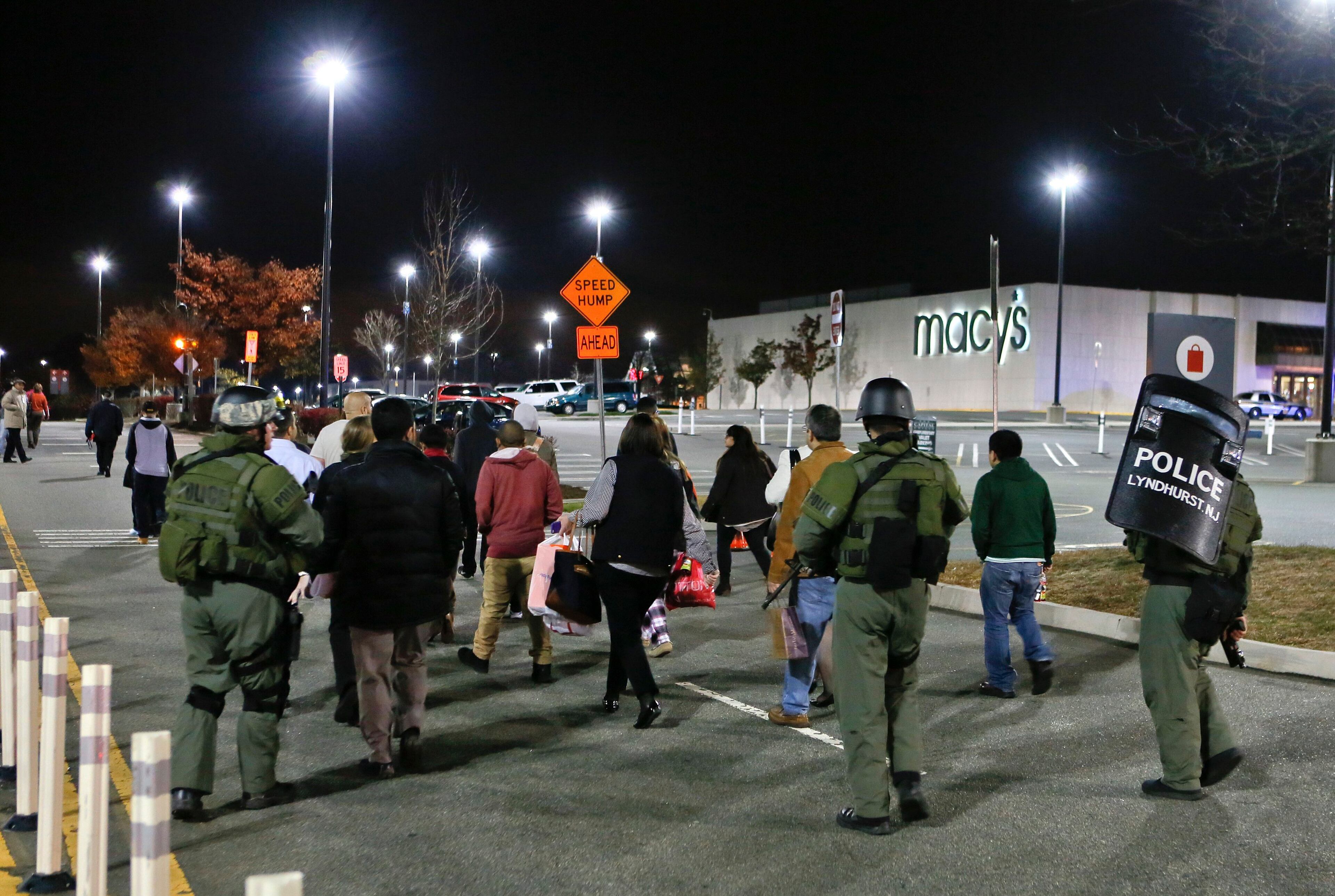 Policemen escort a group of workers and shoppers from the Garden State Plaza mall after a lock down during police response to reports that a gunman had fired shots in the mall, in Paramus, New Jersey November 5, 2013. A person with a gun opened fire on Monday evening in the massive New Jersey shopping mall shortly before closing time, leading police to evacuate the mall and search for the shooter, but no injuries were reported, officials said. REUTERS/Ray Stubblebine