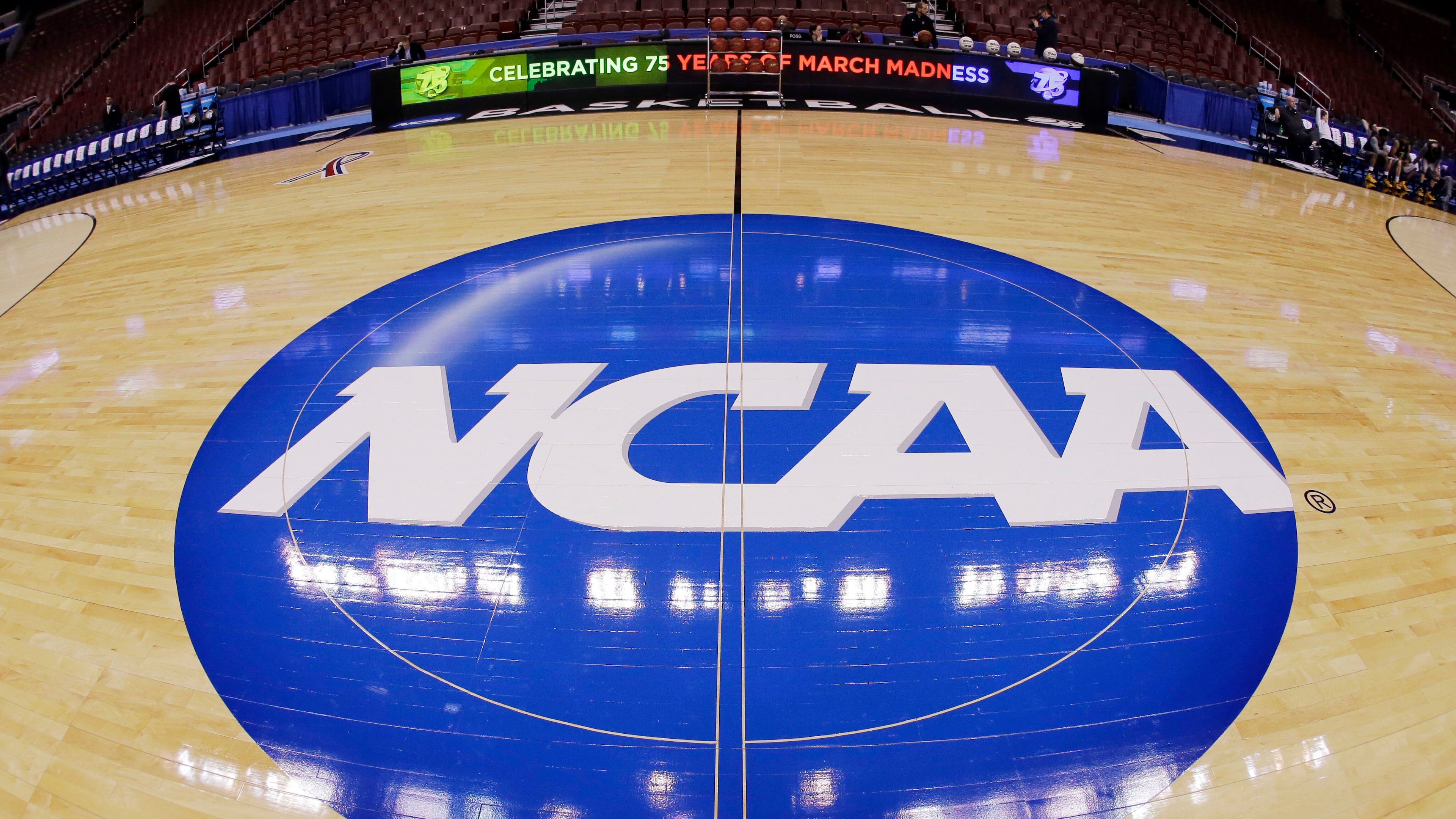 FILE - This photo taken with a fisheye lens shows the NCAA logo displayed at mid-court before Albany's practice for a second-round game of the NCAA college basketball tournament March 21, 2013, in Philadelphia. (AP Photo/Matt Slocum, File)