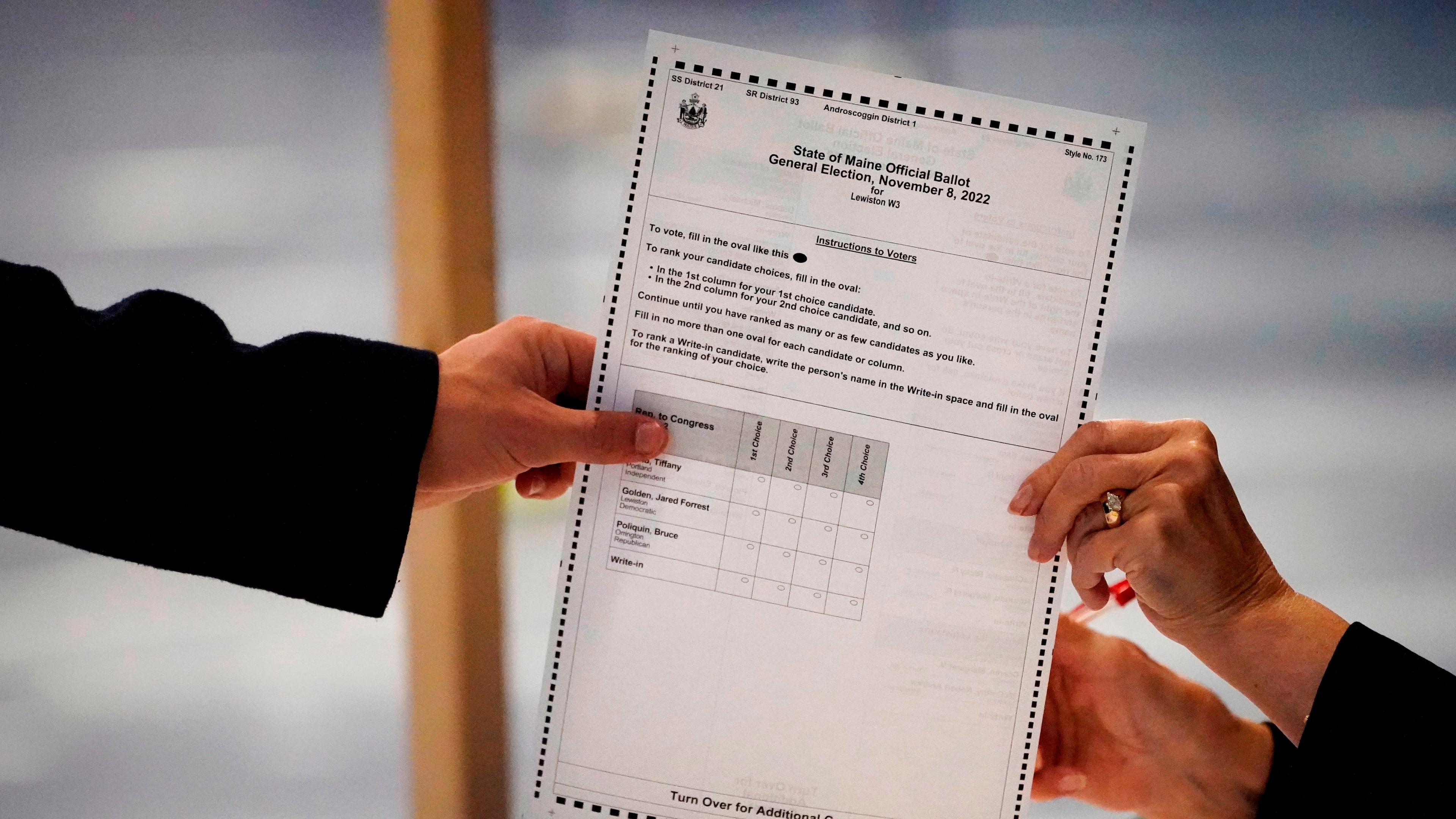 FILE - A ballot is handed to a voter, Nov. 8, 2022, in Lewiston, Maine. (AP Photo/Robert F. Bukaty, File)