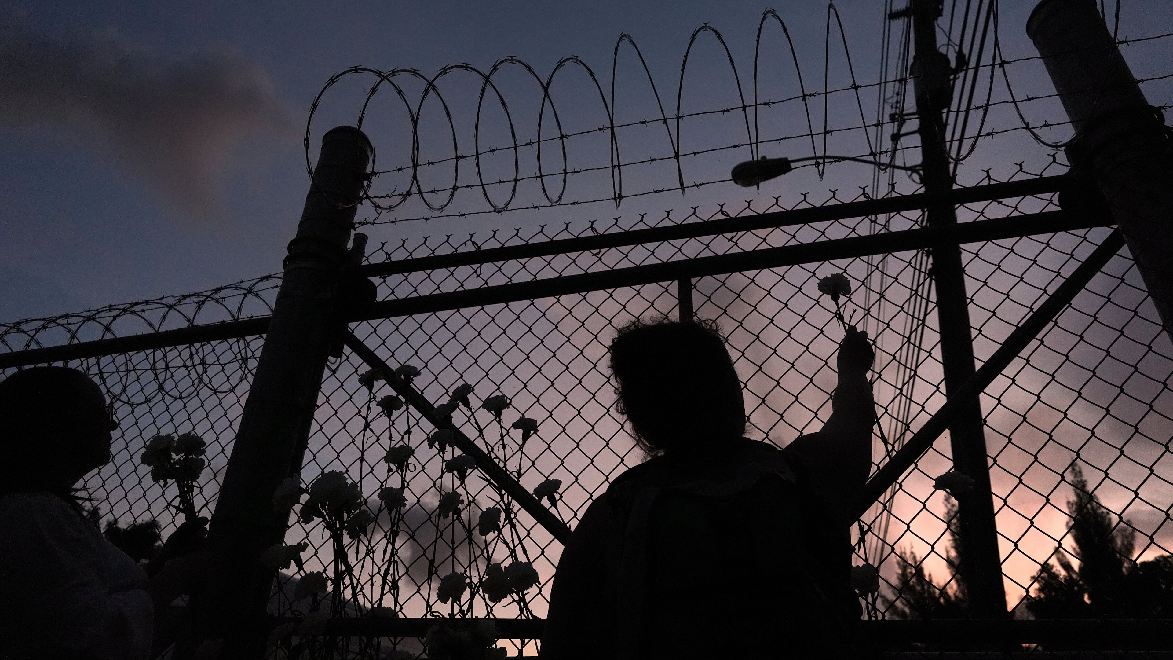 FILE - People place flowers on a fence outside Krome Detention Center in Miami, Saturday, May 24, 2025, during a vigil to recognize people who have died in U.S. Immigration and Customs Enforcement custody as well as those affected by mass deportations. (AP Photo/Rebecca Blackwell, File)