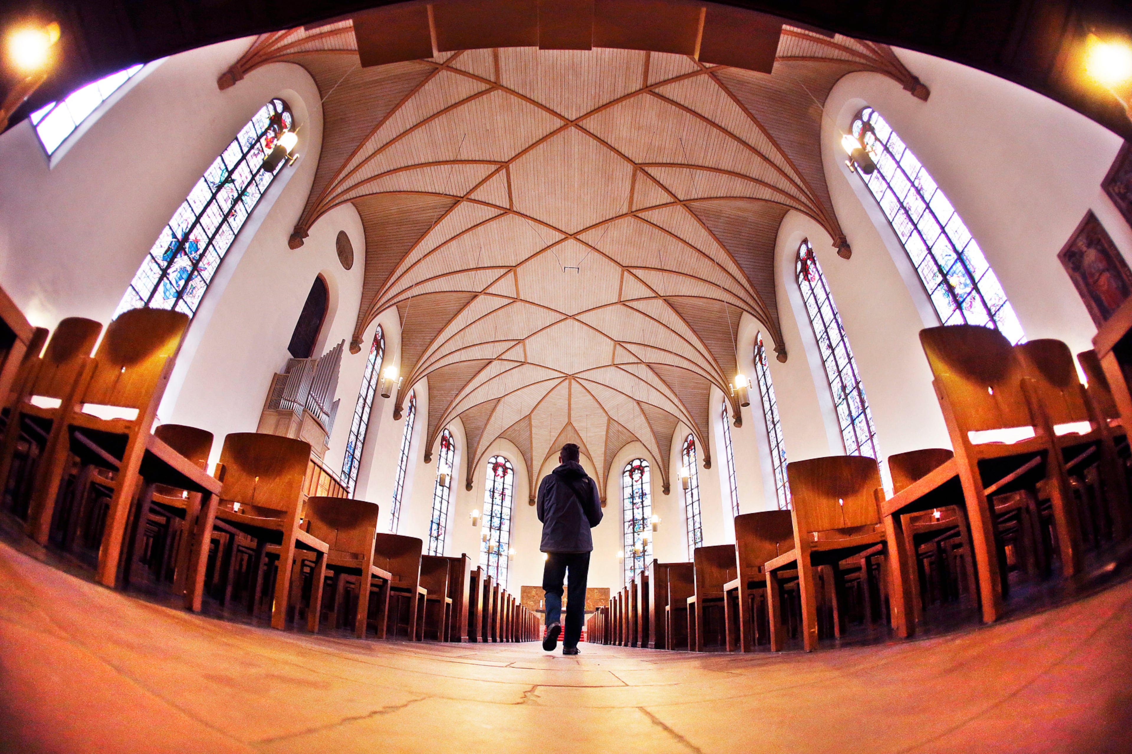 A tourist walks in the St.Katharinen church in Frankfurt, Germany, Tuesday, Oct. 11, 2016. The church that is located in the city centre was originally built in the 17th century. After it was destroyed during World War II it was rebuilt from 1950 to 1954. (AP Photo/Michael Probst)