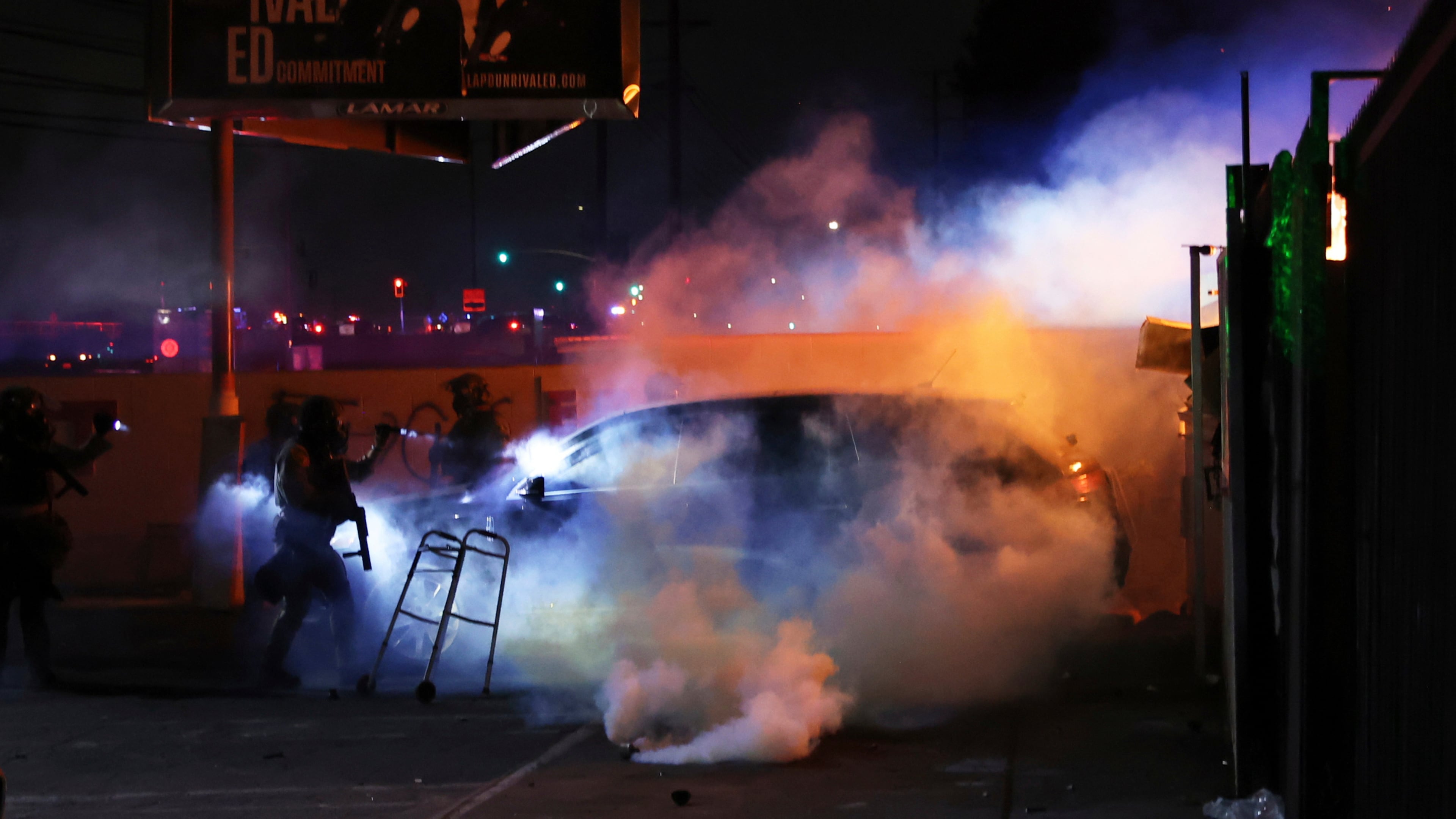 FILE - Law enforcement investigate a car with a person inside during a protest in Compton, Calif., June 7, 2025, after federal immigration authorities conducted operations. (AP Photo/Ethan Swope, file)