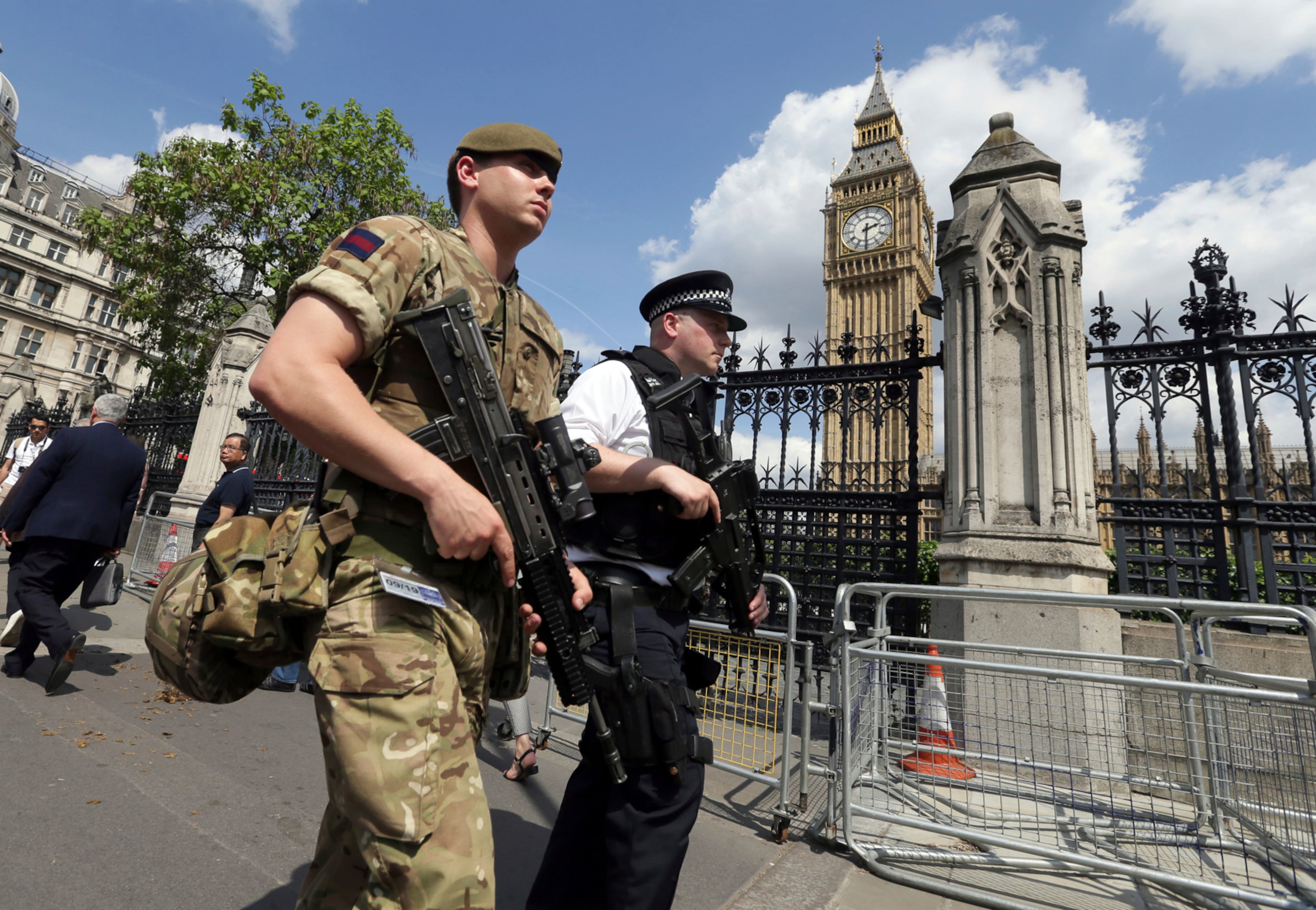 A member of the army joins police officers in Westminster, London, Wednesday, May 24, 2017. Britons will find armed troops at vital locations Wednesday after the official threat level was raised to its highest point following a suicide bombing that killed more than 20, as new details emerged about the bomber. (AP Photo/Tim Ireland)