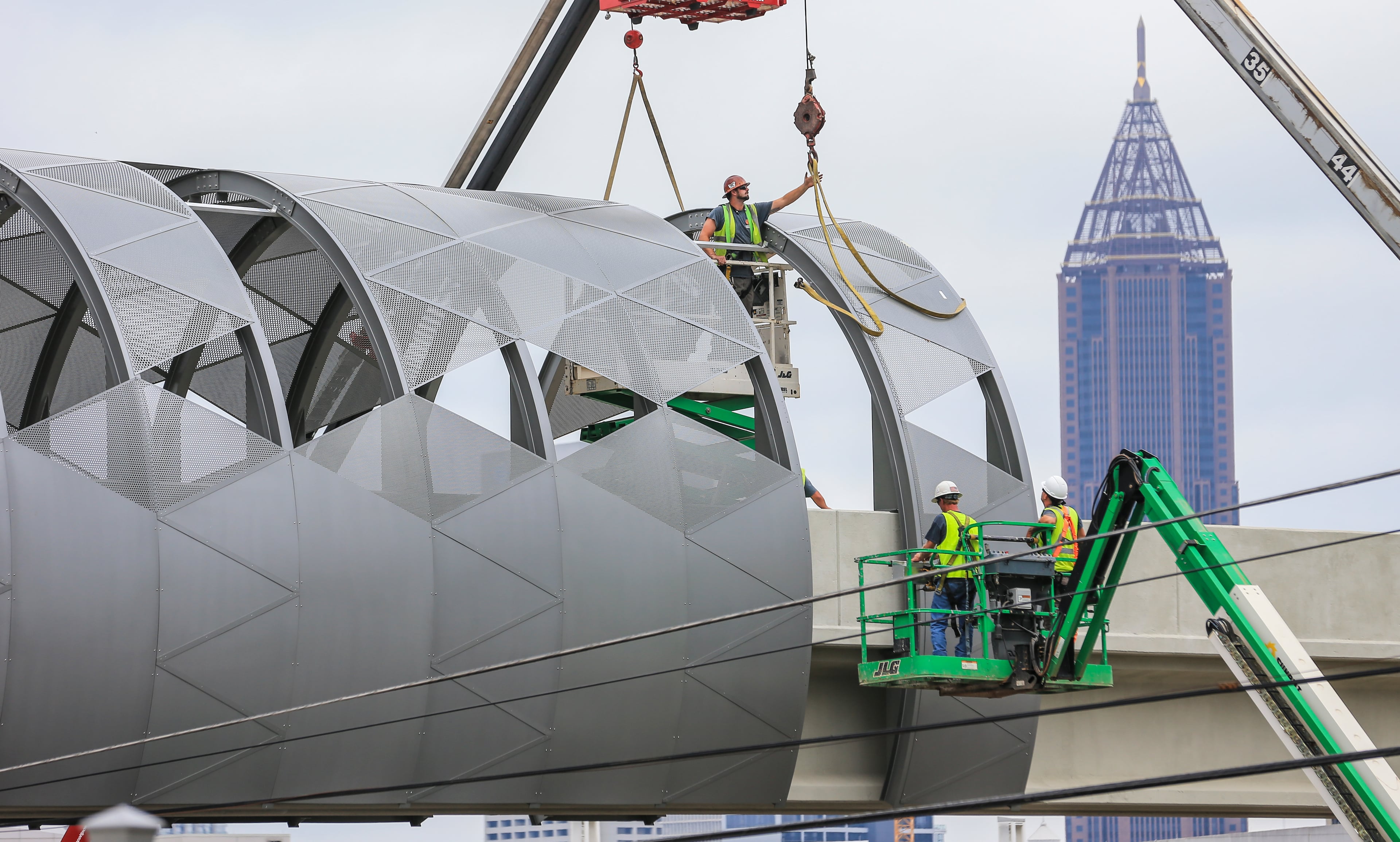 August 21, 2018 Atlanta: Temperatures were in the 70s thanks to a cold front that made its way to metro Atlanta on Tuesday August 21, 2018 as construction workers continued putting into place the covering of the Northside Drive Pedestrian Bridge that will connect Mercedes-Benz Stadium and the Vine City MARTA station. The bridge moves pedestrian traffic to the stadium gates on The Home Depot Backyard side of the stadium. Both will be opening sometime in 2018 before the Super Bowl. Temperatures are expected to be in the mid-80s the rest of this week, according to Channel 2. Commuters can expect lows in the 60s and 70s during their morning drive to work. JOHN SPINK/JSPINK@AJC.COM