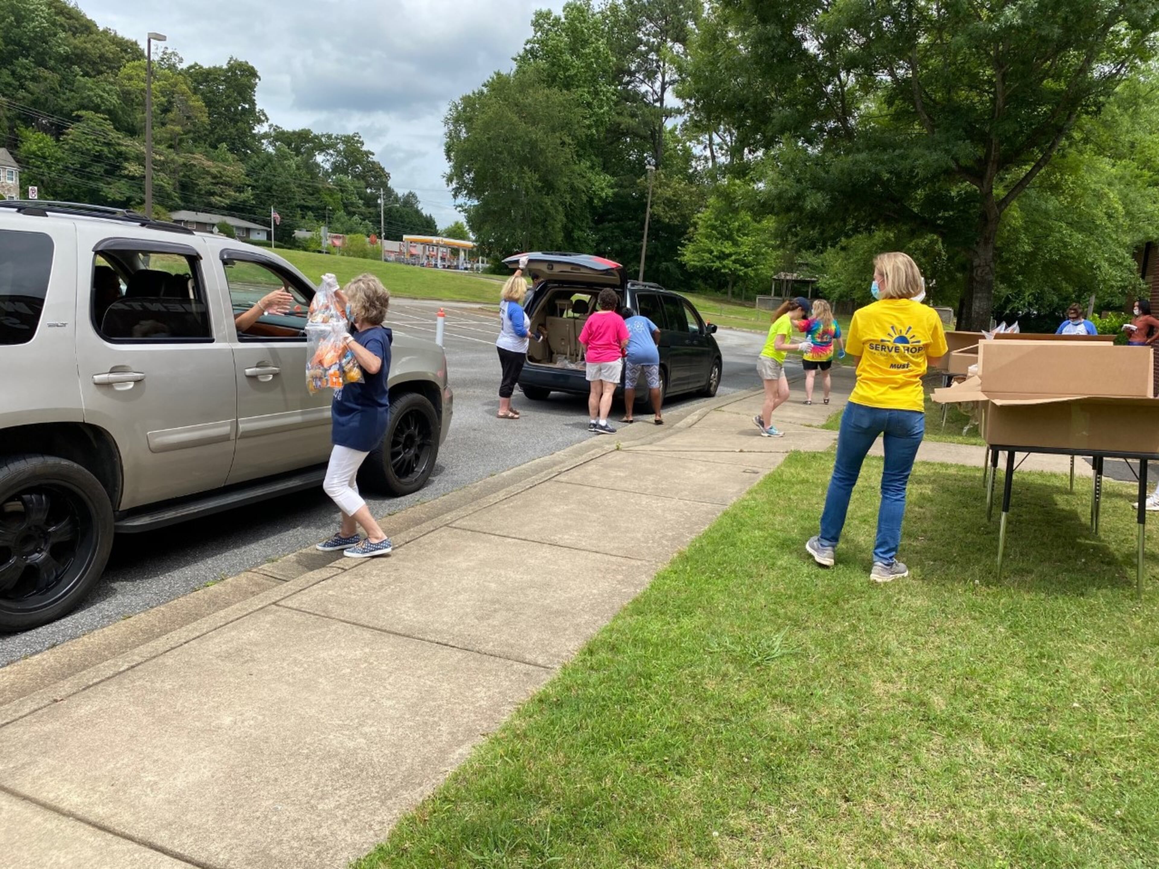 Volunteers and teachers from Blackwell and Bells Ferry Elementary hand out MUST Summer Lunch kits.