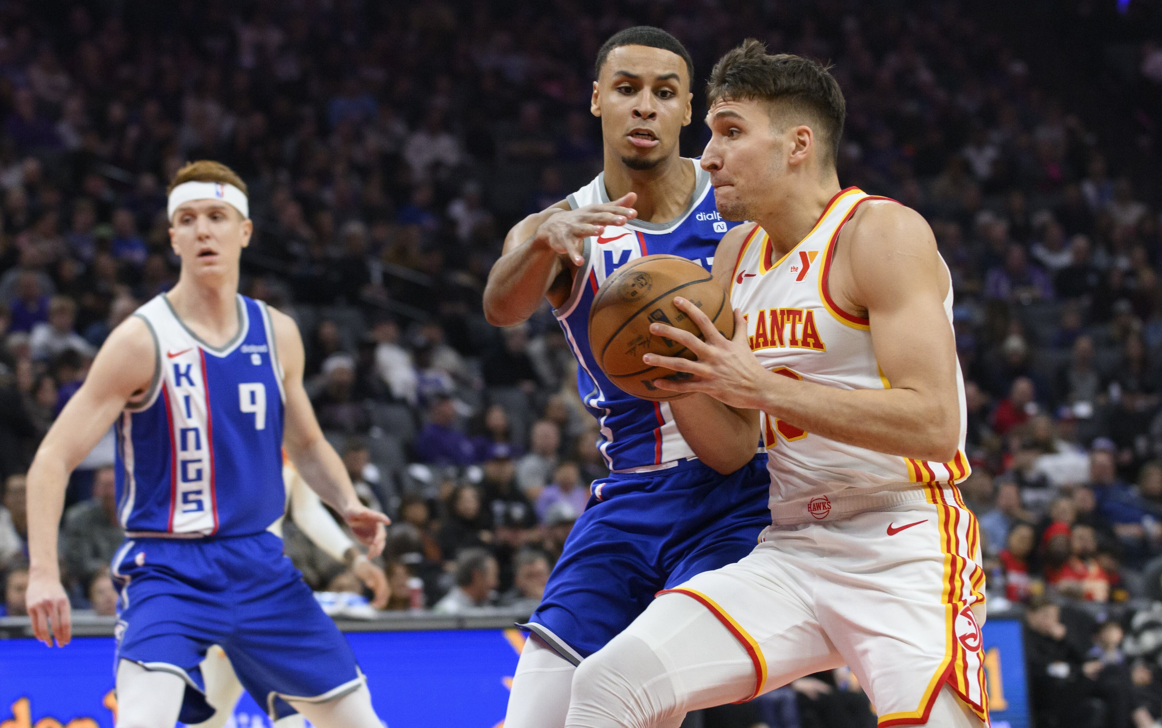 Hawks guard Bogdan Bogdanovic (right) drives past Kings forward Keegan Murray during the first half of an NBA basketball game in Sacramento, Calif., Monday, Jan. 22, 2024. (AP Photo/Randall Benton)