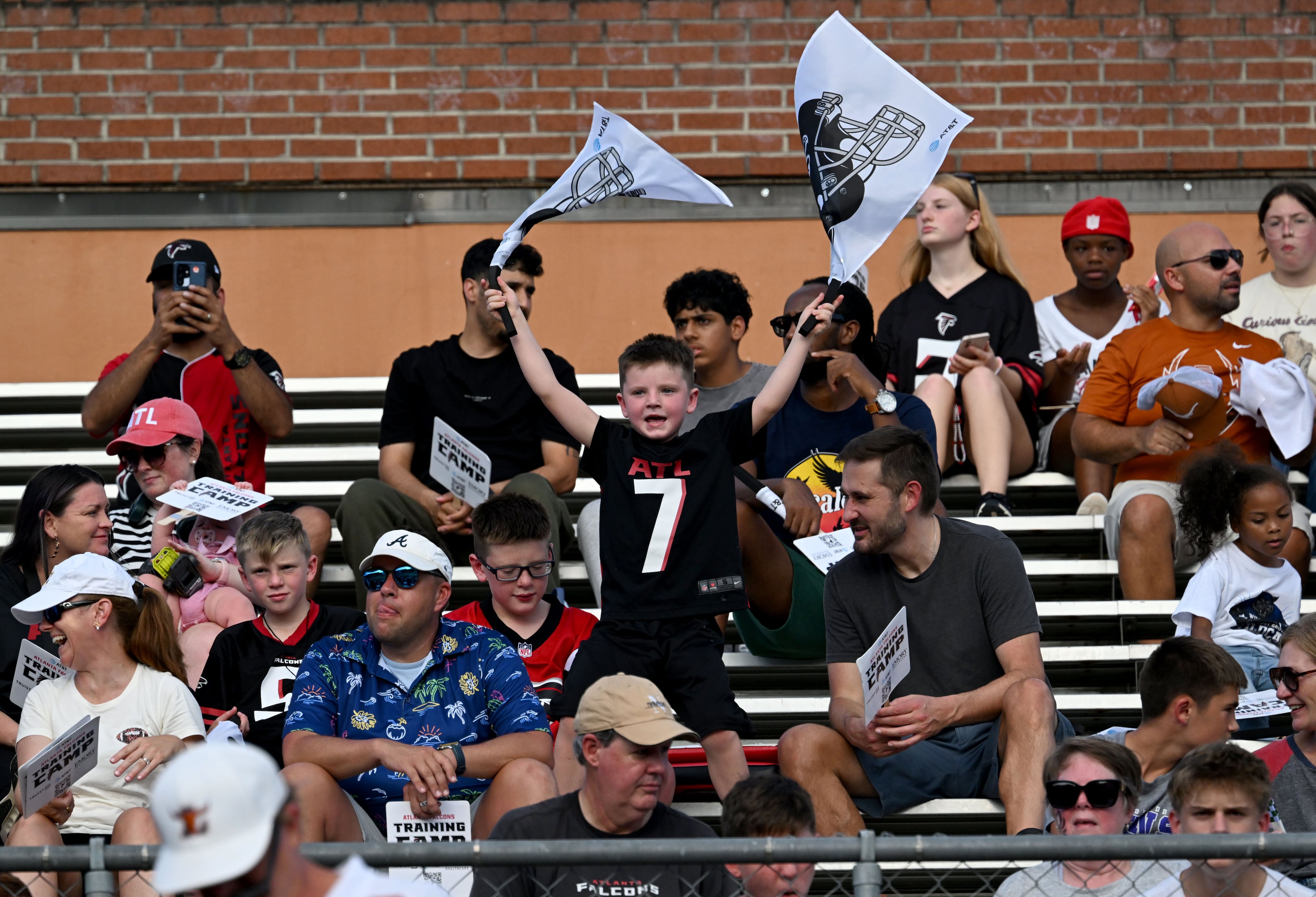 Football fans cheer as they watch their favorite players in action during the Atlanta Falcons' "Saturday Night Lights" practice Saturday, Aug. 8, 2026, at Lanier High School in Sugar Hill. (Hyosub Shin/AJC)