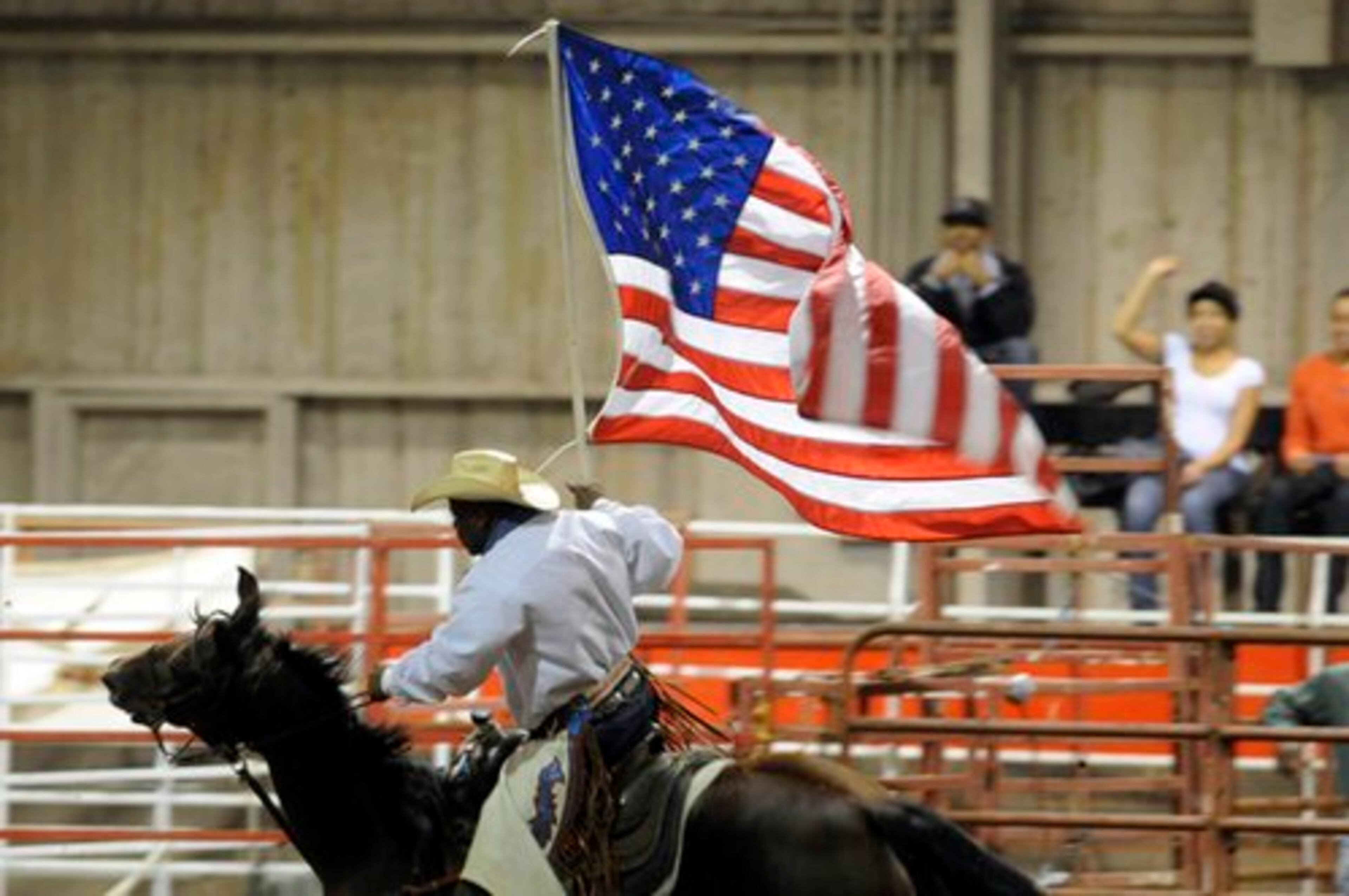 Cedric Haynes of Hempstead Texas, General Manager of the Bill Pickett Invitational Rodeo, rides the arena with the American Flag during introductions Saturday October 2nd at the Henderson Arena in College Park. The Bill Pickett Invitational Rodeo, celebrating its 27th season, showcases African American cowboys, expanding on the Black West experiences of yesterday and today and of the cultural pride associated with contributions made by African Americans.