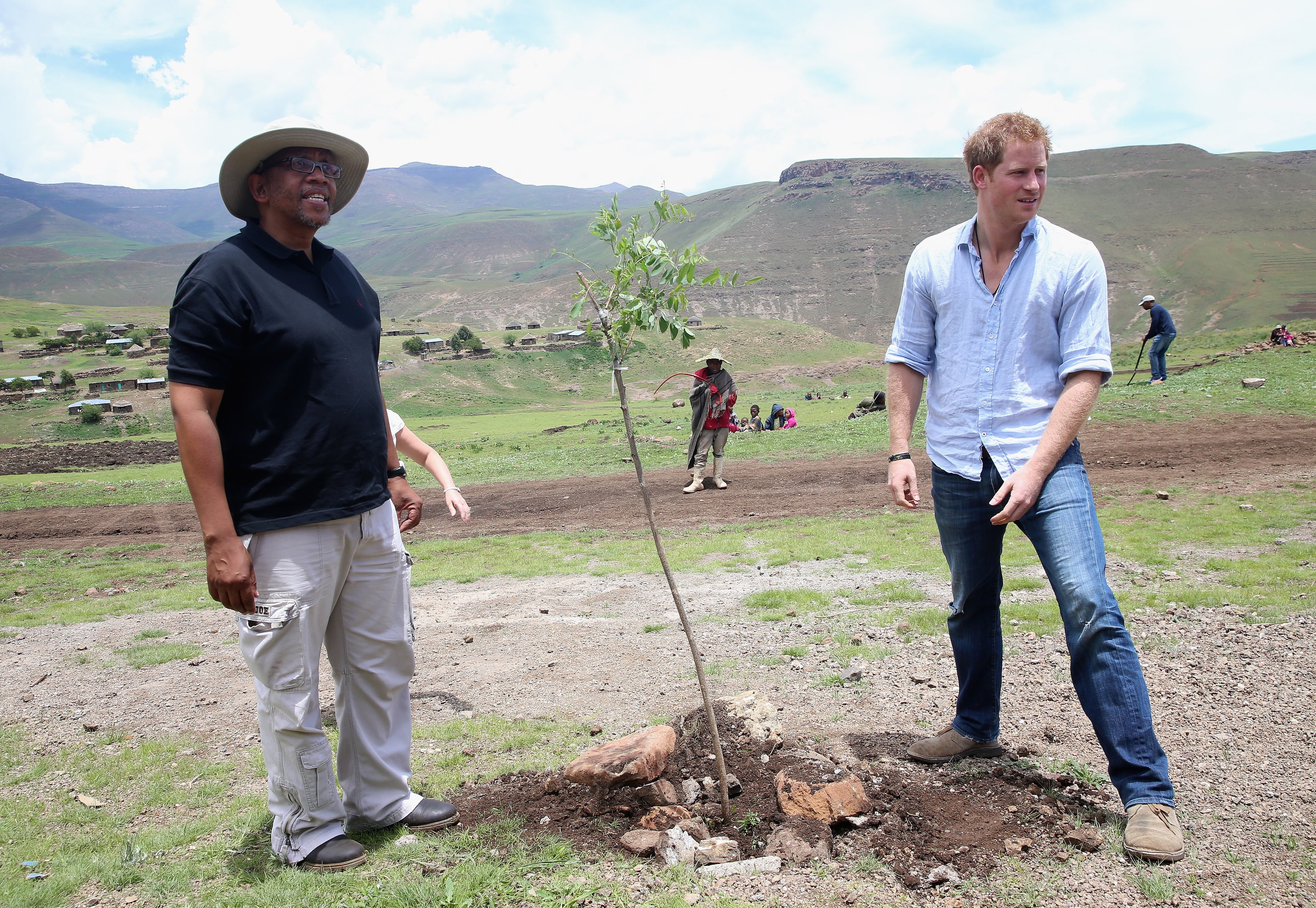 Prince Harry plants a tree with Prince Seeiso of Lesotho (in hat) during a visit to a herd boy night school constructed by Sentebale on December 8, 2014 in Maseru, Lesotho. Prince Harry was visiting Lesotho to see the work of his charity Sentebale. Sentebale provides healthcare and education to vulnerable children in Lesotho, Southern Africa. The particular theme of his visit was to check on the progress of the Mamohato Childrens Centre which will provide vital support to children affected by HIV. Prince Harry founded Sentebale (which means Forget Me Not in Sesotho) with Prince Seeiso in 2006. (Photo by Chris Jackson/Getty Images for Sentebale)