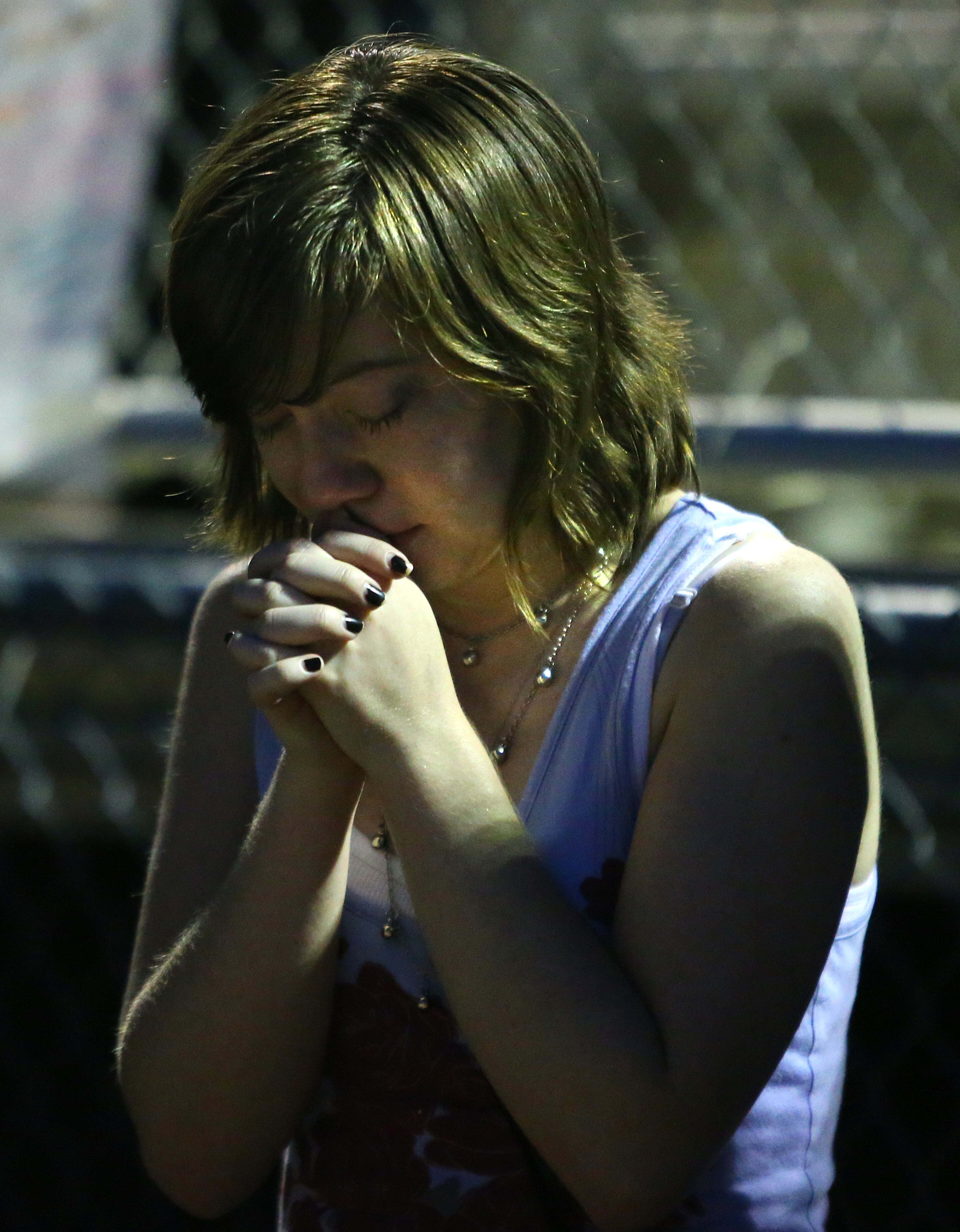 A particpant pray during a candlelight vigil to remember 16-year-old Henry County girl Jasmine Poole in the football stadium at Dutchtown High School on Thursday, May 8, 2014, in Hampton. Poole was killed and two other teens injured in a Wednesday afternoon wreck. CURTIS COMPTON / CCOMPTON@AJC.COM