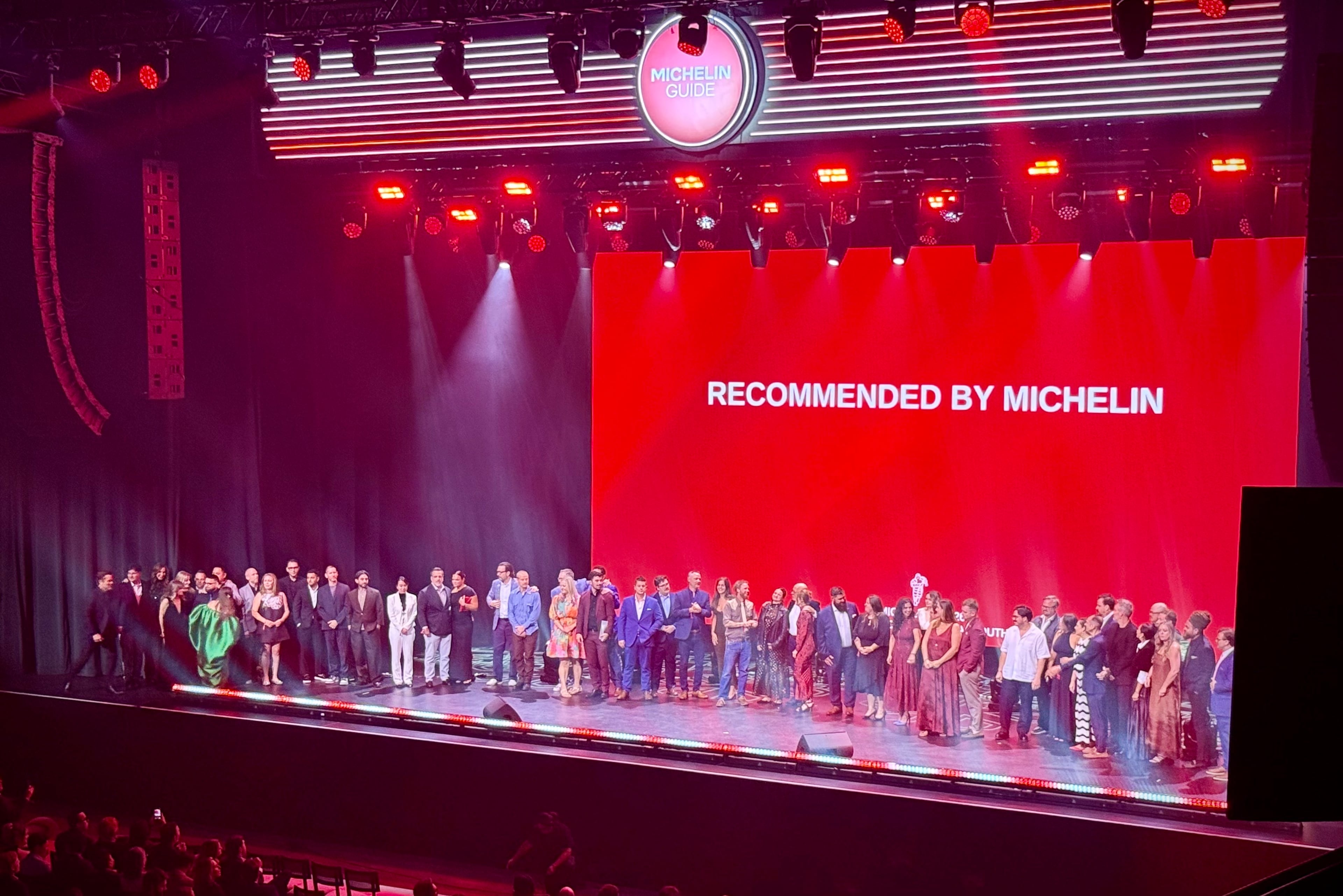 Representatives from restaurants newly recommended in the 2026 Michelin Guide gather on stage at the American South ceremony in Nashville. (Henri Hollis/AJC)