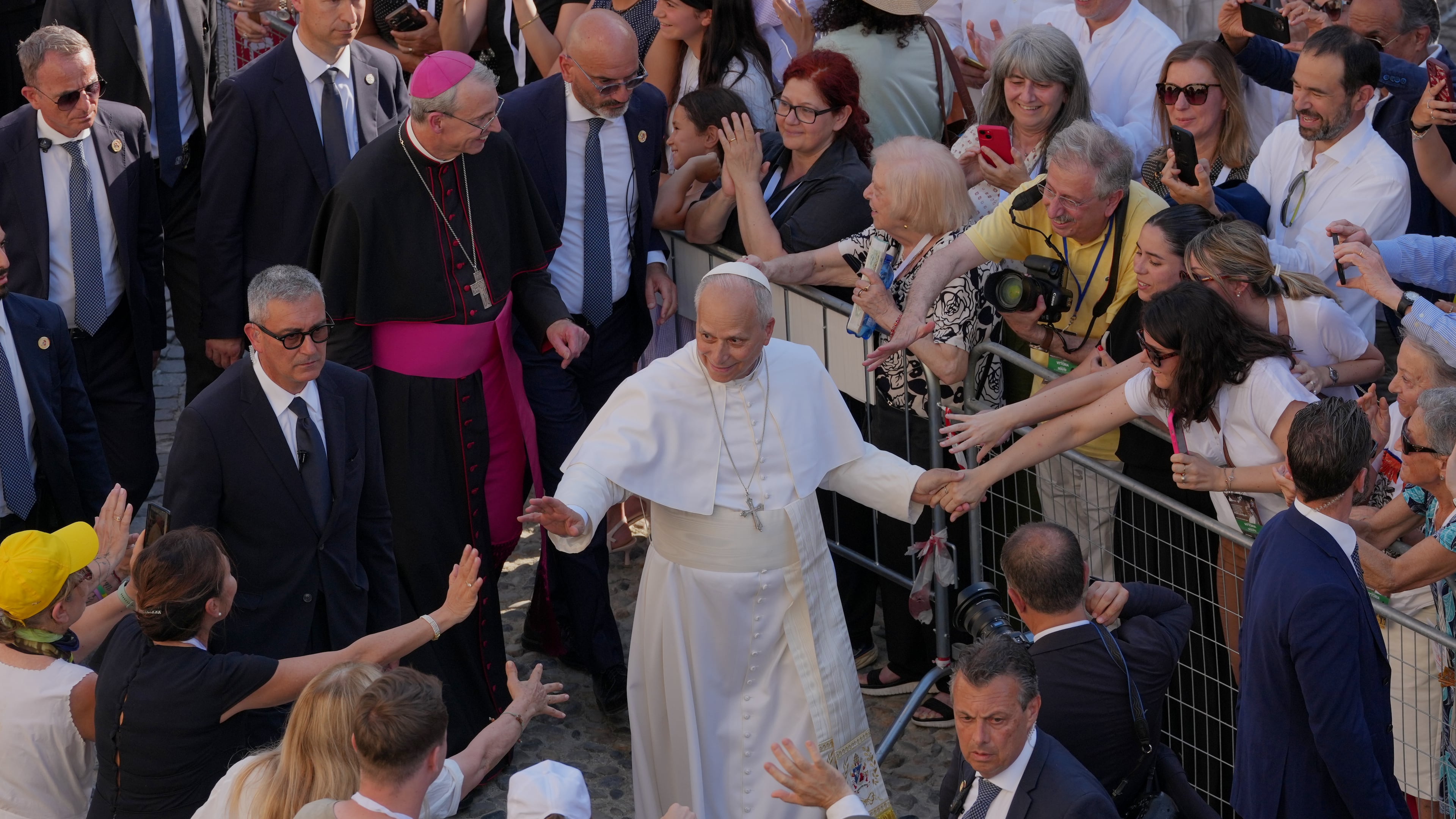 Faithful reach out to Pope Leo XIV as he leaves Pavia Cathedral in northern Italy, Saturday, June 20, 2026. (AP Photo/Antonio Calanni)