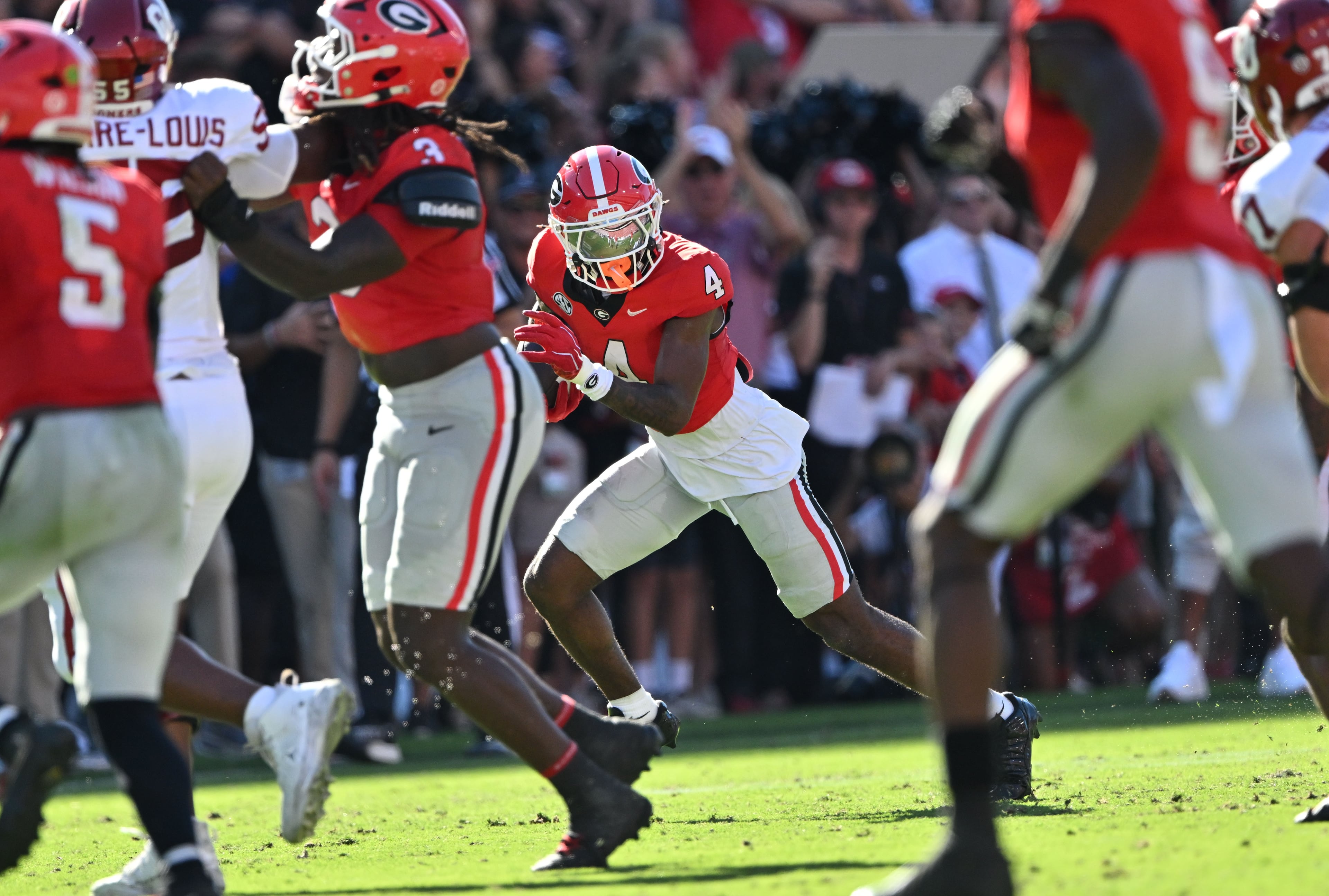 Georgia defensive back KJ Bolden (center) intercepts a pass and runs it back for a touchdown against Oklahoma during the first half in an NCAA football game at Sanford Stadium on Saturday, Sept. 26, 2026, in Athens, Ga. Georgia went on to win 41-13. (Hyosub Shin/AJC)