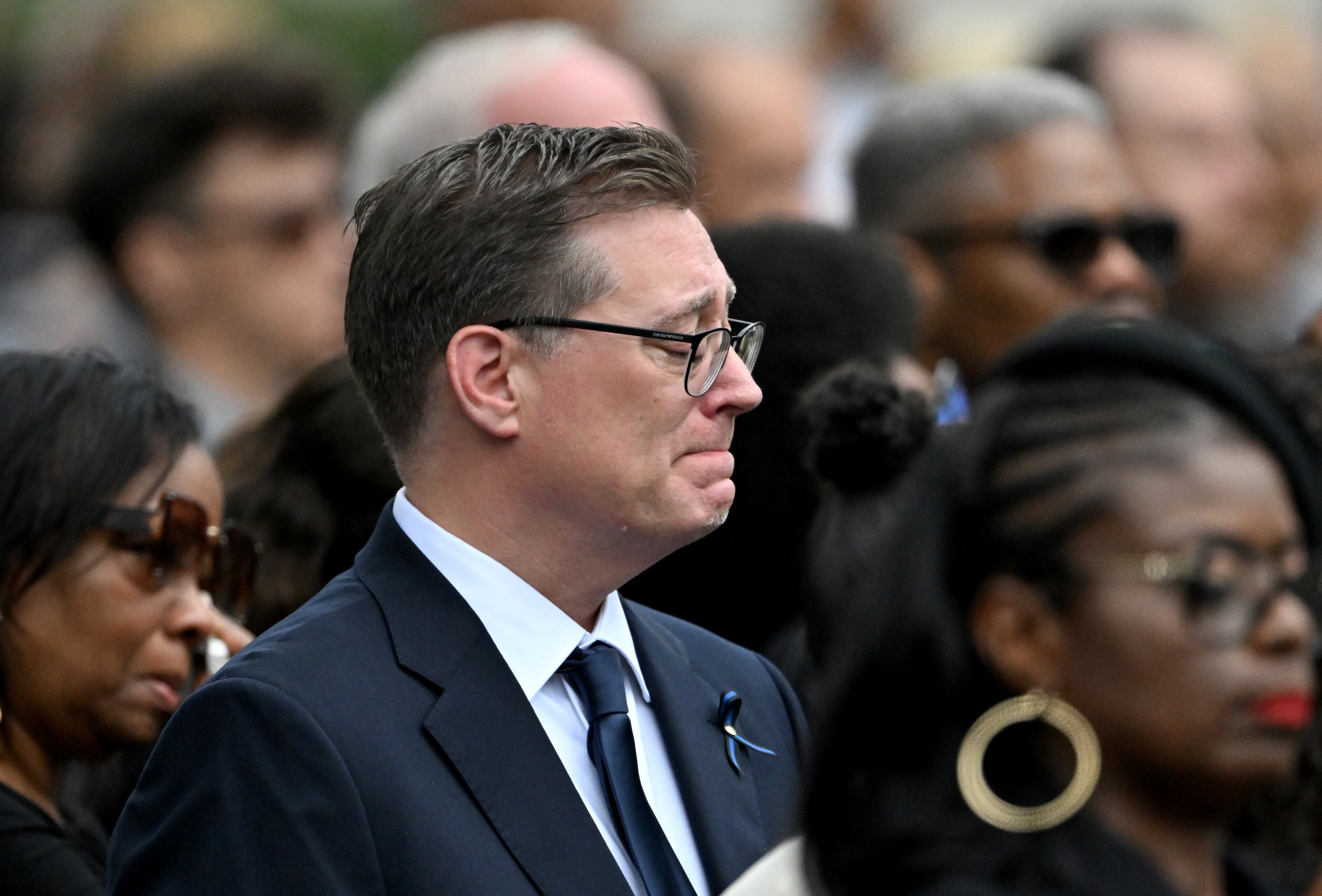 A mourner reacts during the Final Honors following the memorial service for DeKalb County police Officer David Rose, who was killed while responding to the Aug. 8 shooting at the CDC, outside the First Baptist Church Atlanta, Friday, August 22, 2025, in Atlanta. Hyosub Shin / AJC)