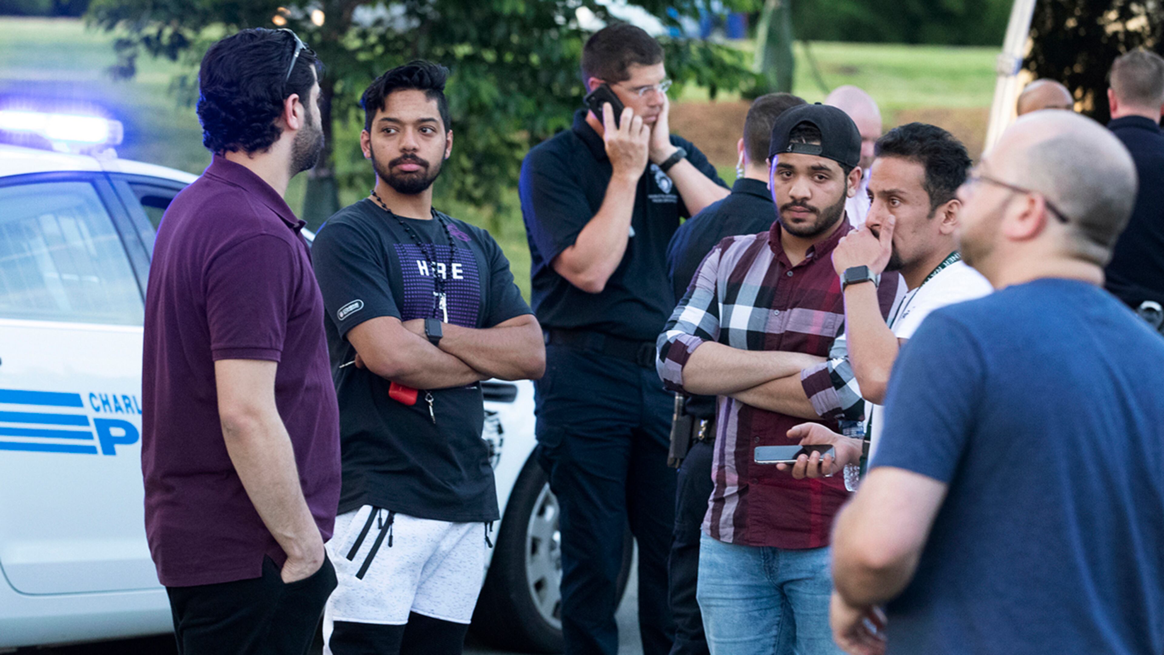 People gather across from the campus of UNC Charlotte after a fatal shooting at the school, Tuesday, April 30, 2019, in Charlotte, N.C.
