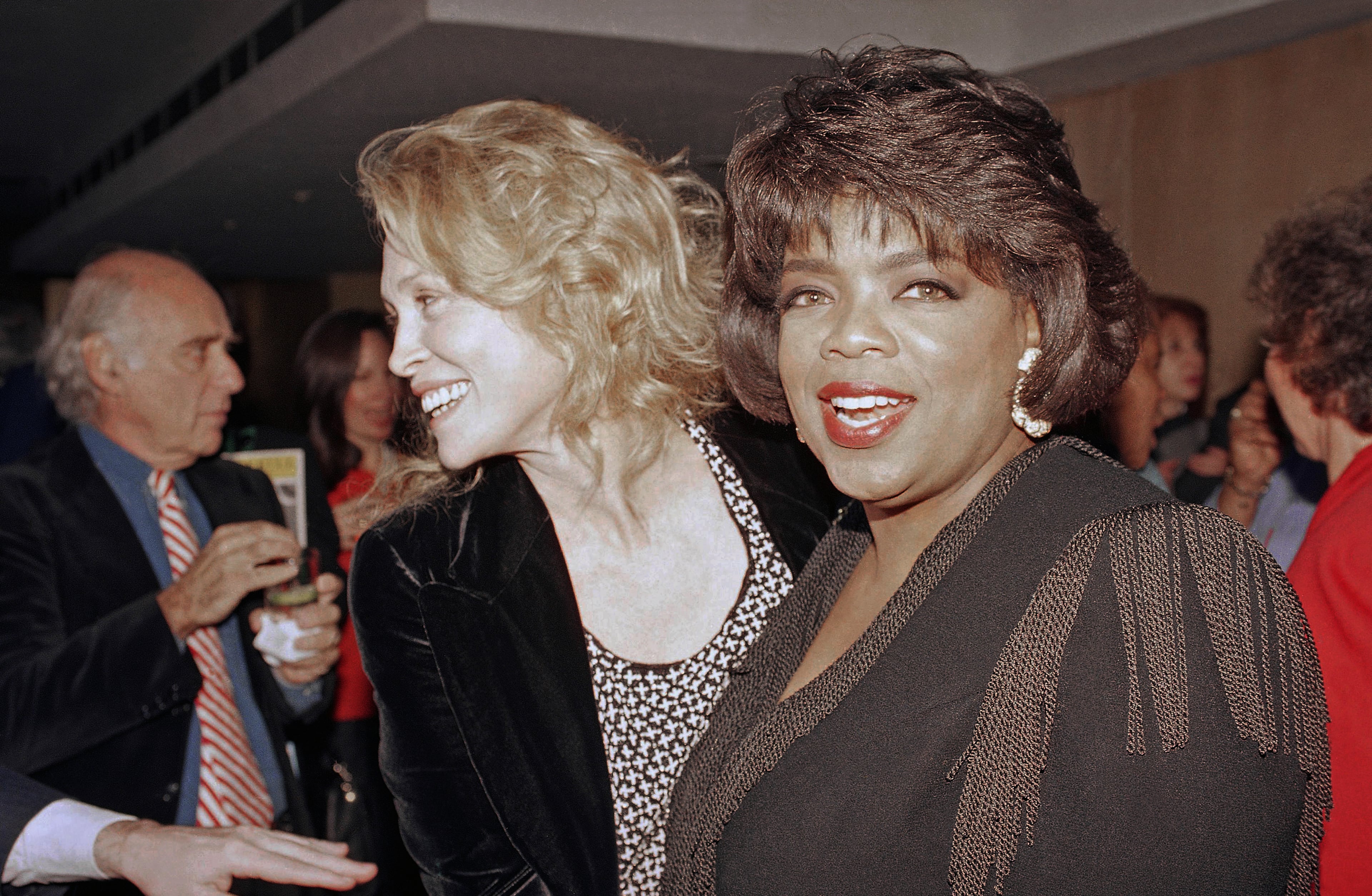 Oprah Winfrey, right, and Faye Dunaway arrive at the opening night party for "From the Mississippi Delta" in New York, Nov. 12, 1991. The autobiographical play, written by Dr. Endesha Ida Mae Holland, chronicles the playwright's life from prostitute to Ph. D. Winfrey is one of the show's producers and it marks her first time as a New York theater producer. (AP Photo/Mark Lennihan)
