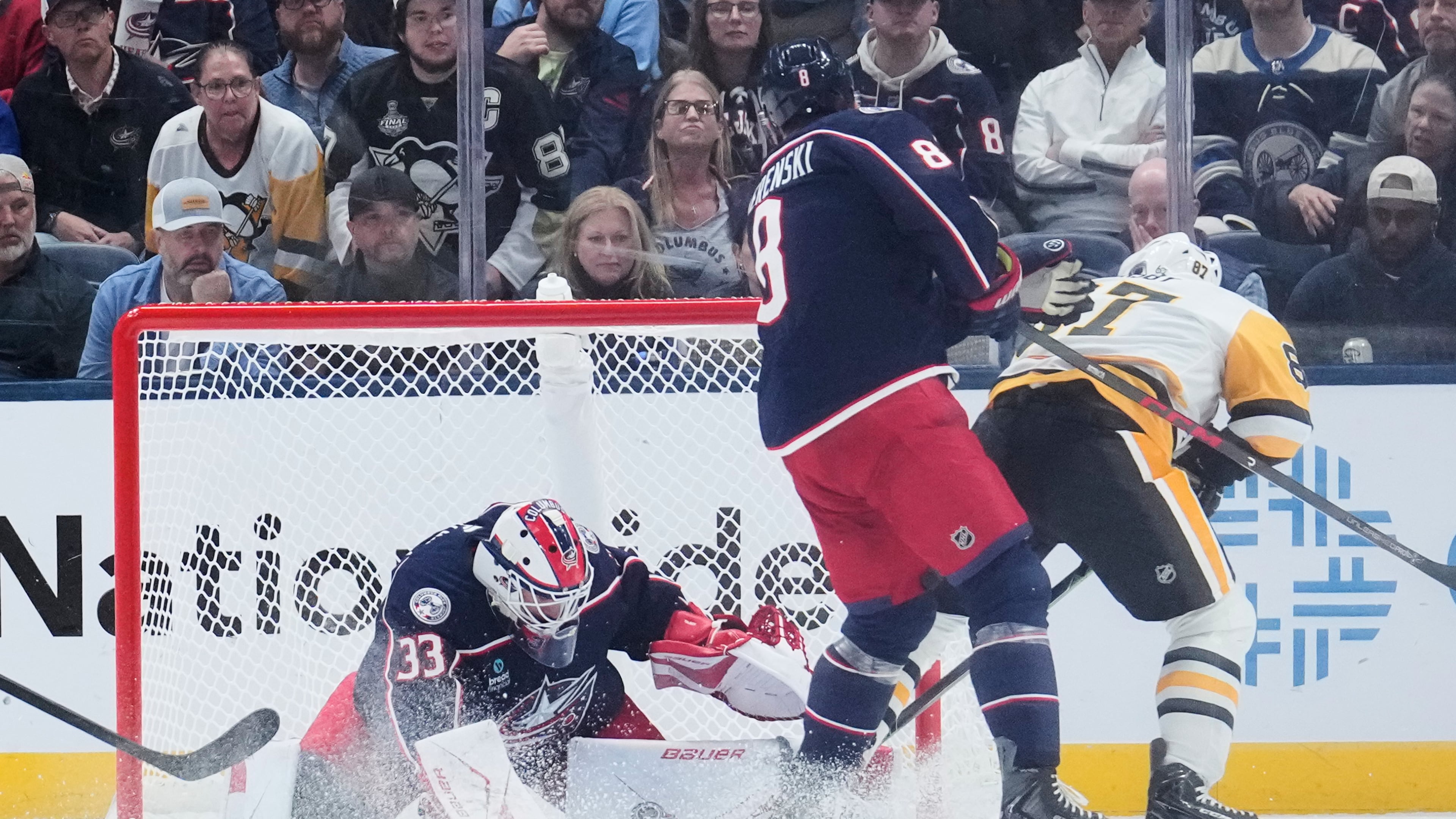 Columbus Blue Jackets goalie Cam Talbot (33) blocks a shot by Pittsburgh Penguins center Sidney Crosby (87), next to Zach Werenski (8), in overtime of an NHL hockey game in Columbus, Ohio, Friday, Oct. 9, 2026. (AP Photo/Sue Ogrocki)