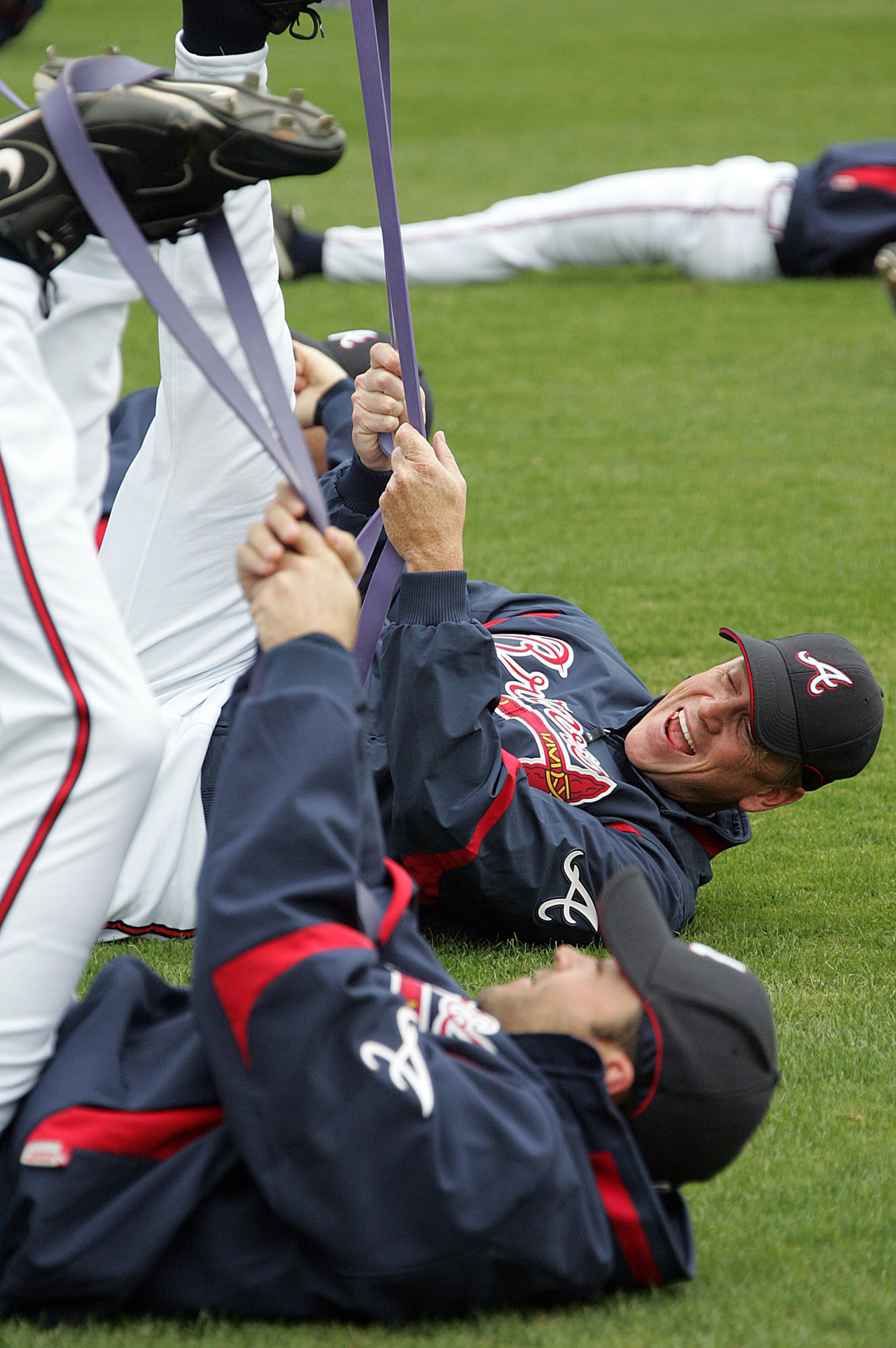 Braves pitchers Mike Hampton (foreground) and Tom Glavine share a laugh while stretching in the morning before they play an exhibition at Disney's Wide World of Sports in 2008.